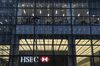 Empty desks sit above a HSBC Holdings Plc logo at their office building in the Canary Wharf financial, business and shopping district of London.