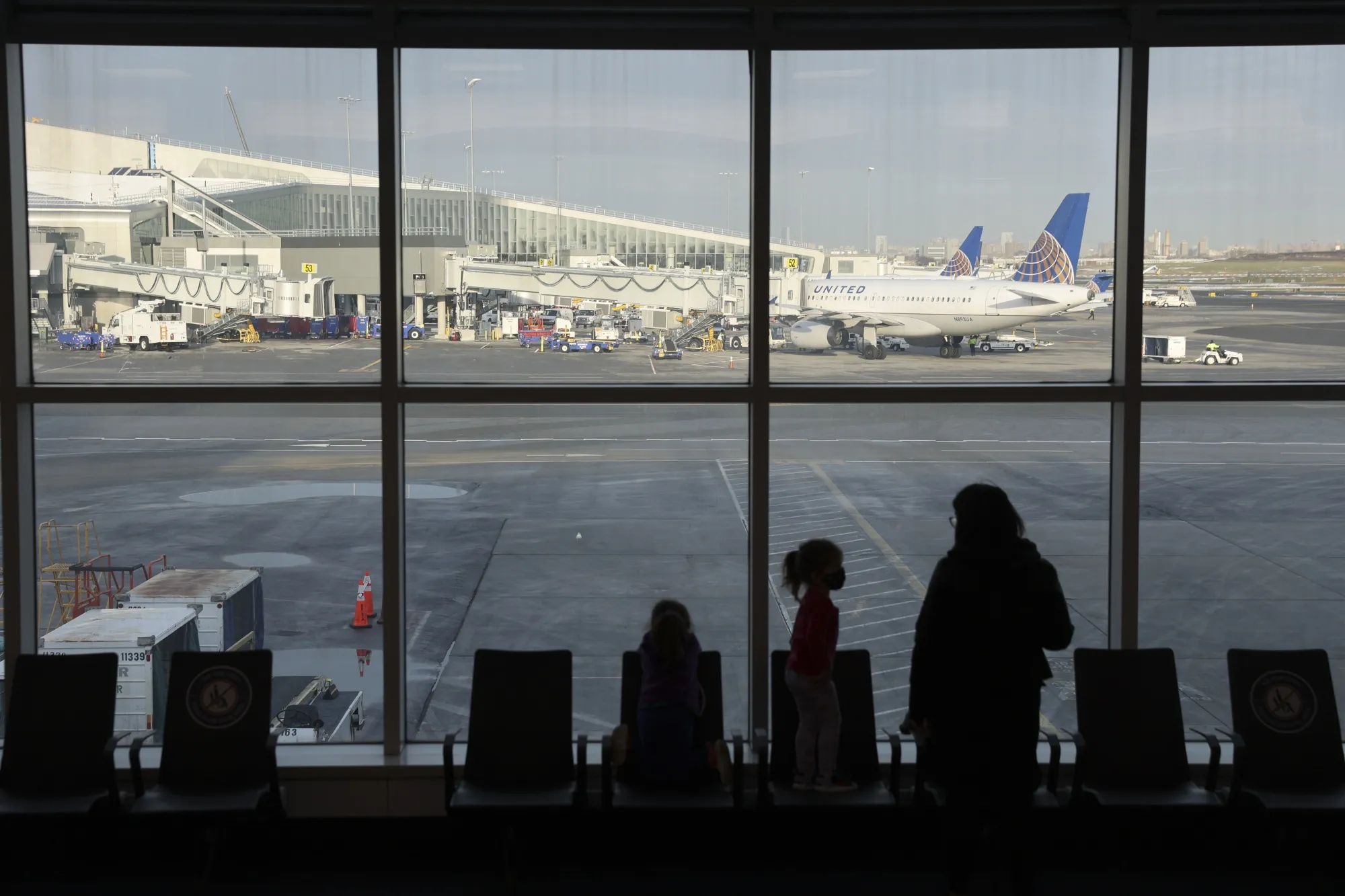 Travelers look out a window at LaGuardia Airport&nbsp;in New York.