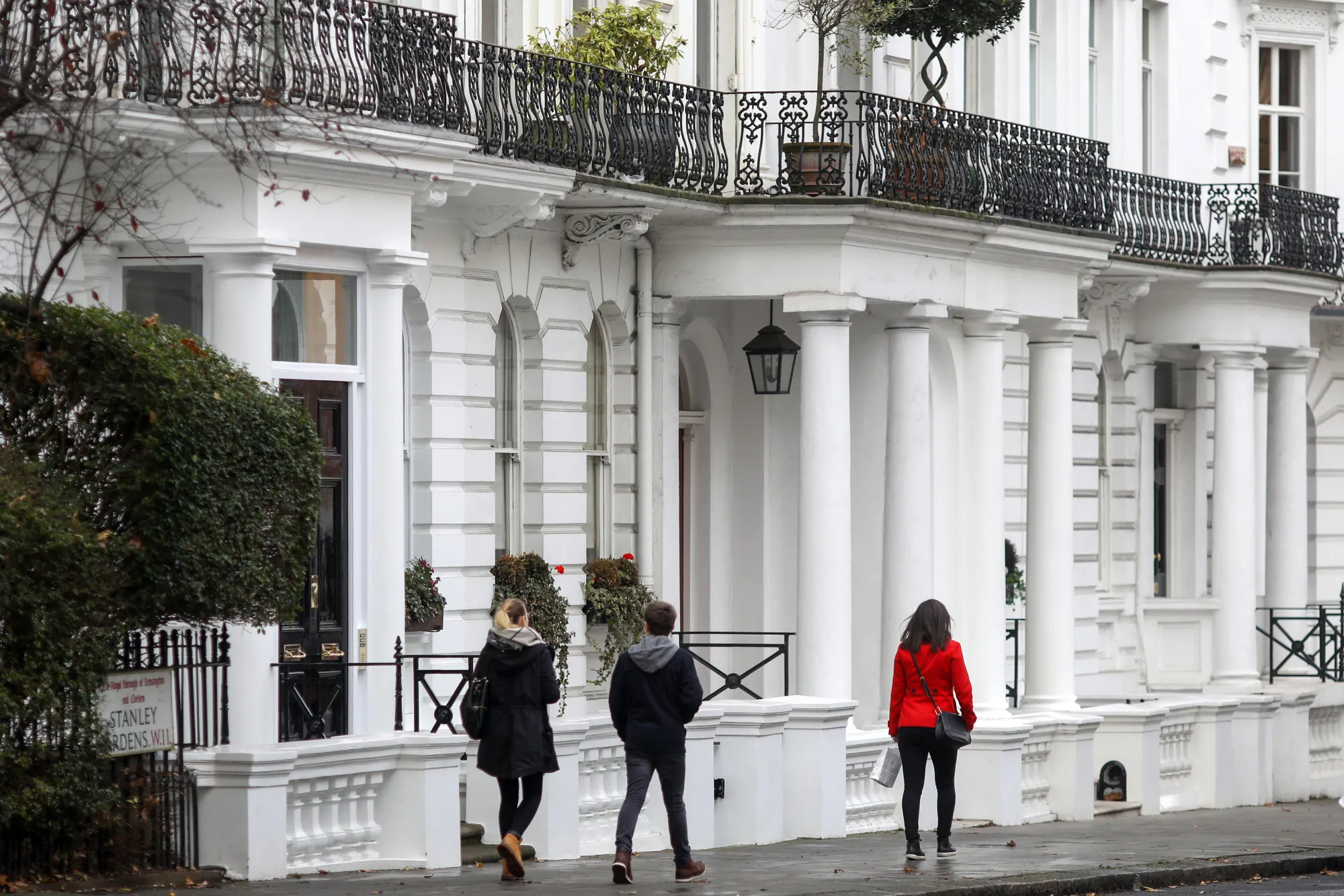 Pedestrians pass luxury residential properties in the Notting Hill area of London.
