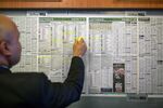 A worker highlights non-racers in newspaper racing guide at a William Hill bookmakers in London.