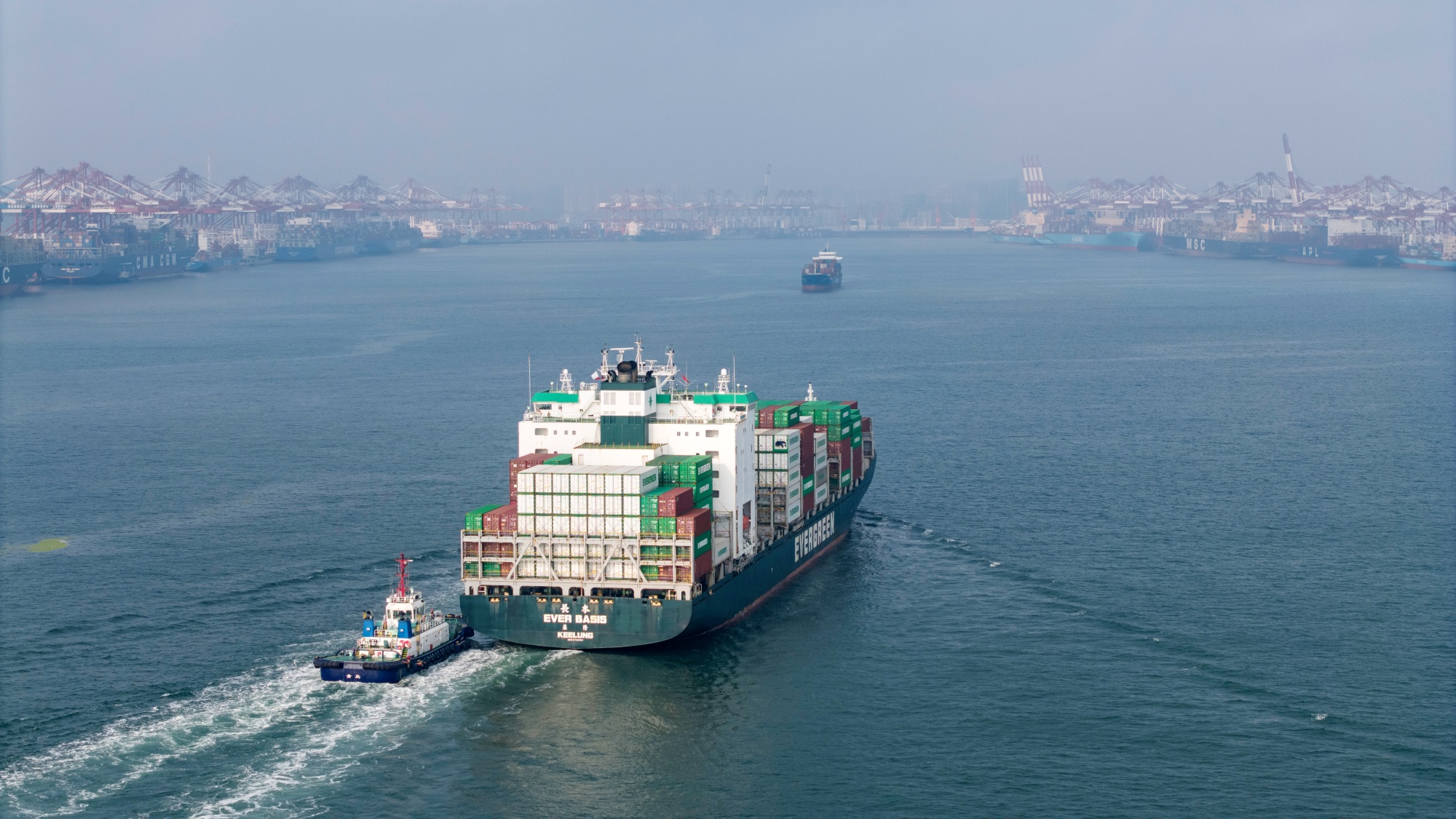 The Evergreen Marine Corp. Ever Basis container ship sails past the Qingdao Port in Qingdao, China, on Thursday, July 10, 2025. The world&#39;s two biggest economies agreed in May to lower their tariffs on each others’ exports for 90 days, with the US reducing its levies on most Chinese imports to 30%, from an earlier level of 145%. Source: Bloomberg