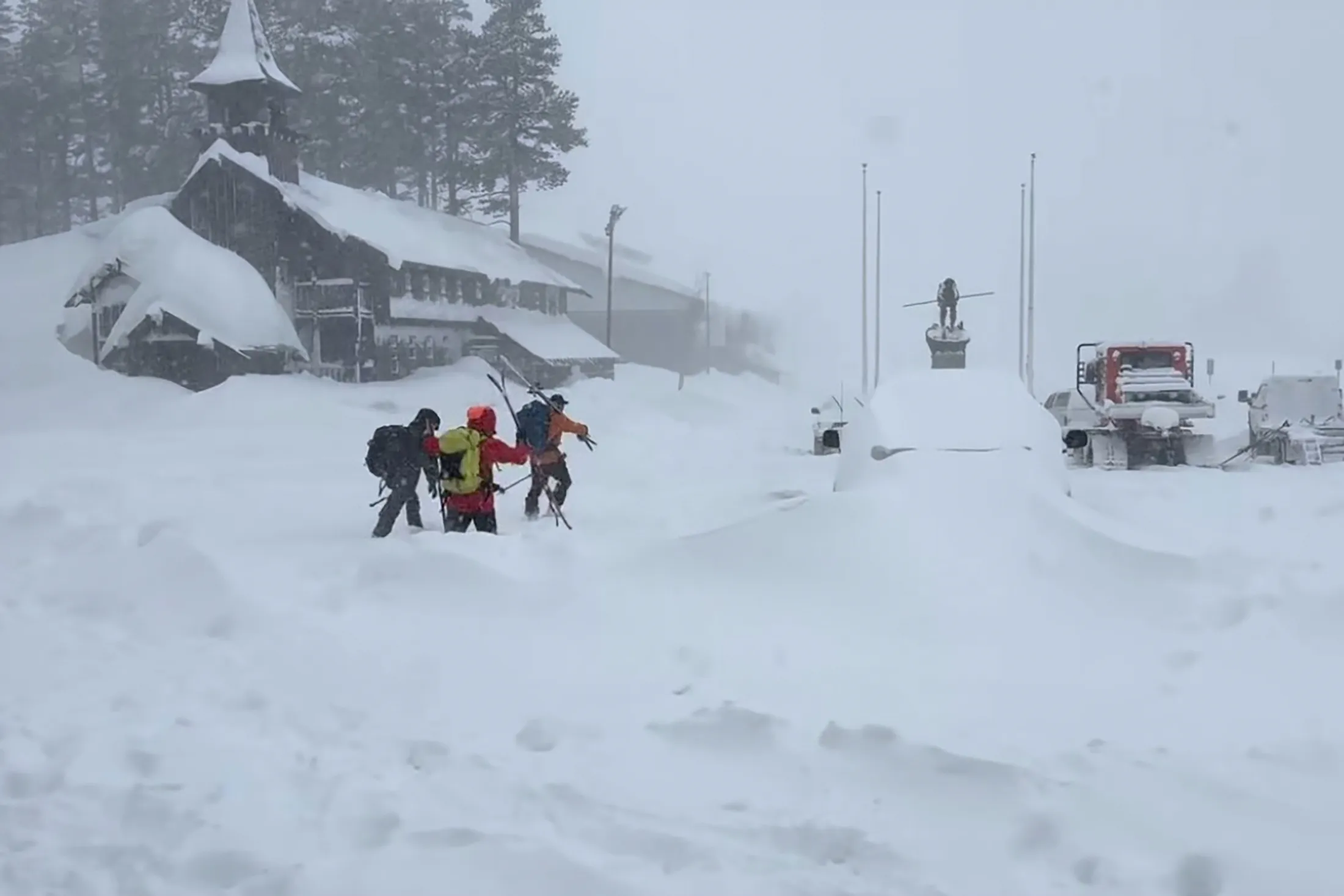 This image provided by the Nevada County Sheriff’s Office shows members of a rescue team hike through snow in Soda Springs, California, on Feb. 17.