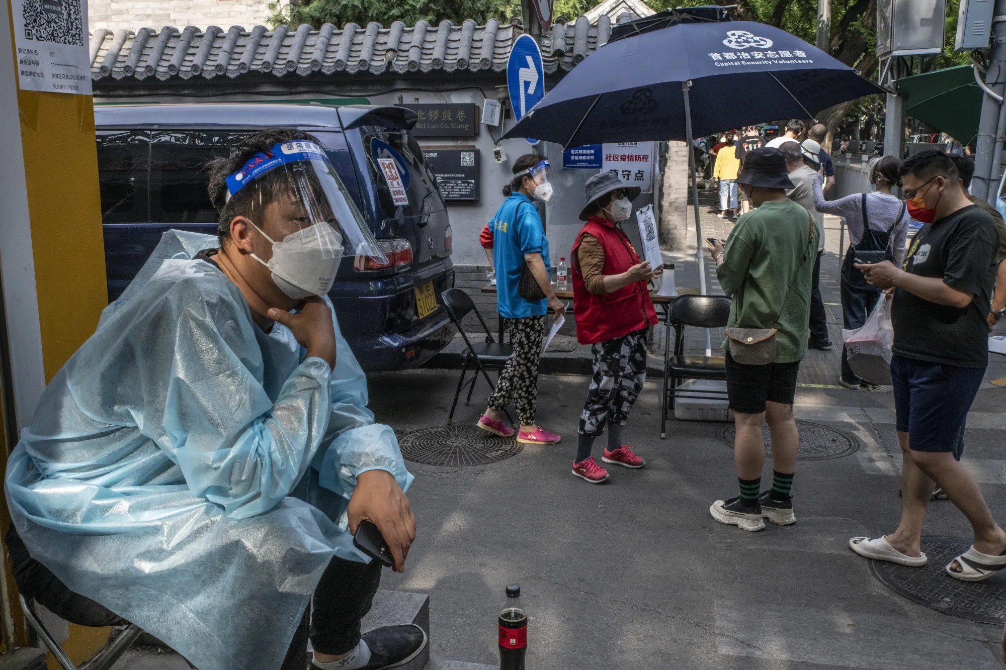 Residents scan health codes before entering a neighborhood in Beijing, China.