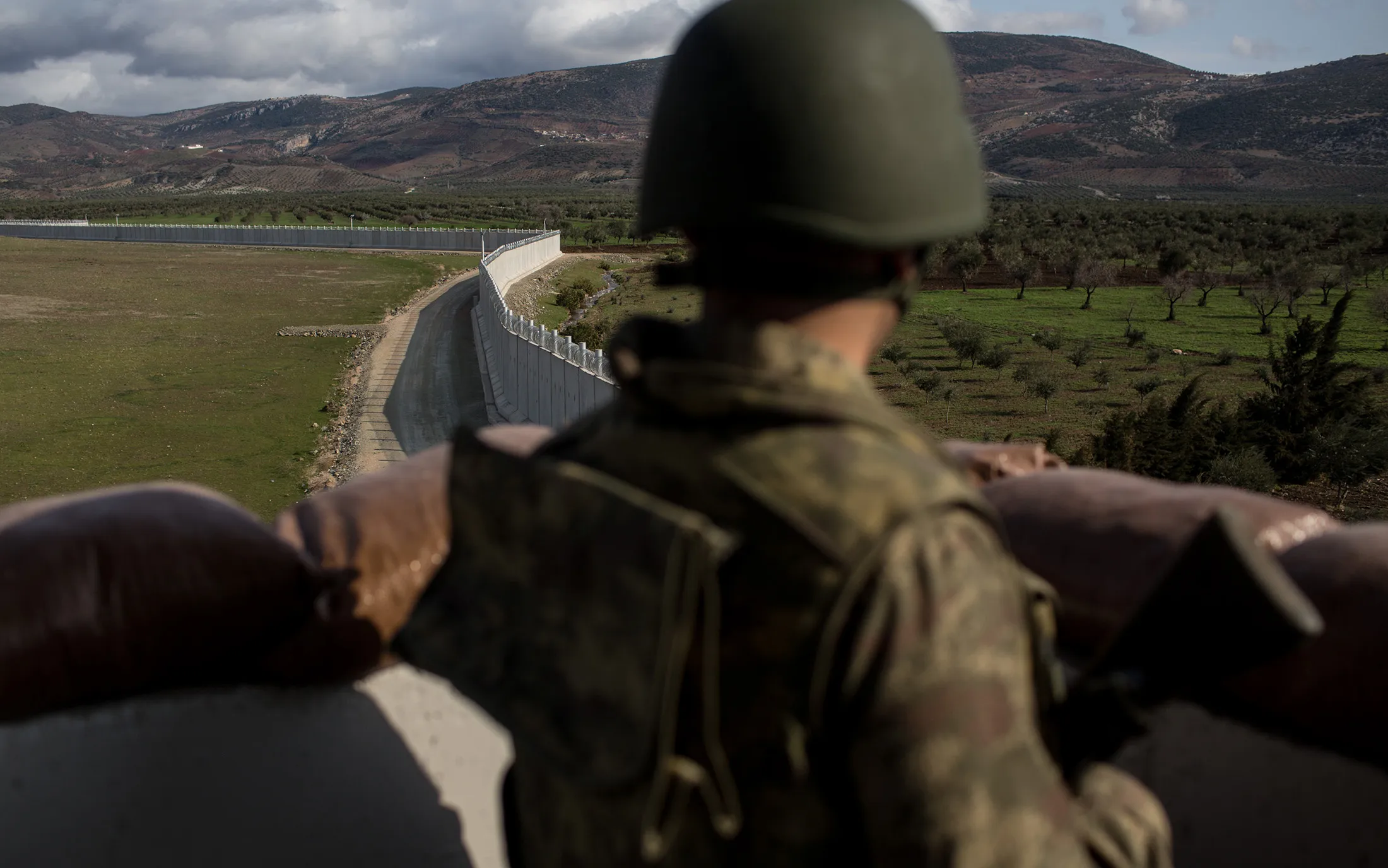 A Turkish soldier&nbsp;looks out over the border wall to Syria in Kilis, Turkey.&nbsp;