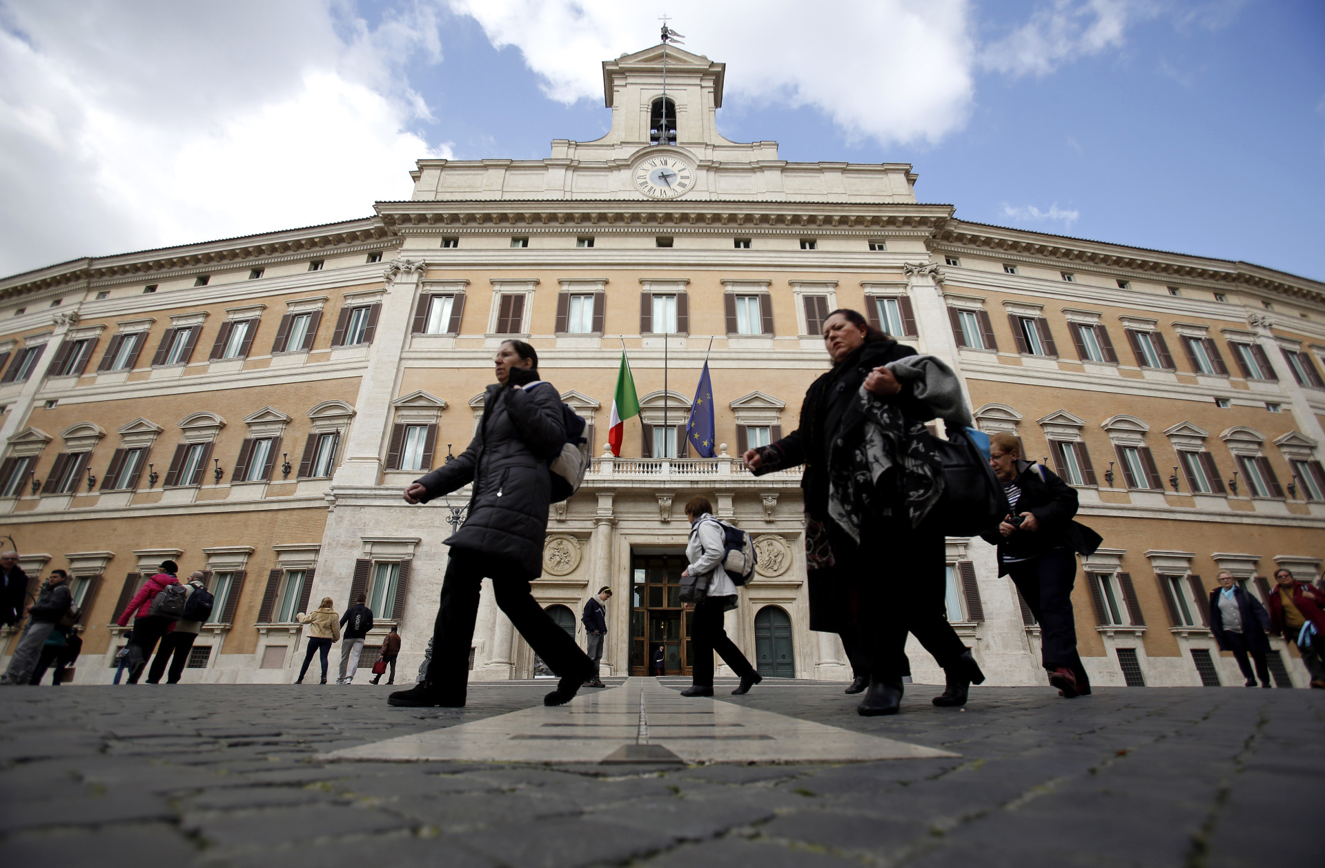Pedestrians pass the Palazzo Montecitorio, Italy's parliament building and office of the Chamber of Deputies, in Rome, Italy, on Friday, Feb. 21, 2014. Italy's government bonds rose, with 10-year securities extending a fourth weekly gain, as Prime-Minister-designate Matteo Renzi prepared to name his cabinet amid speculation he will accelerate economic reform.