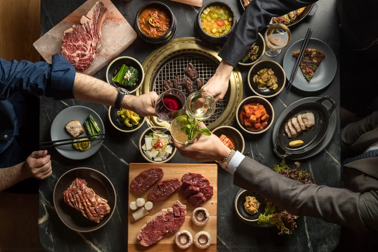A full, toasting&nbsp;table at Cote Korean Steakhouse.