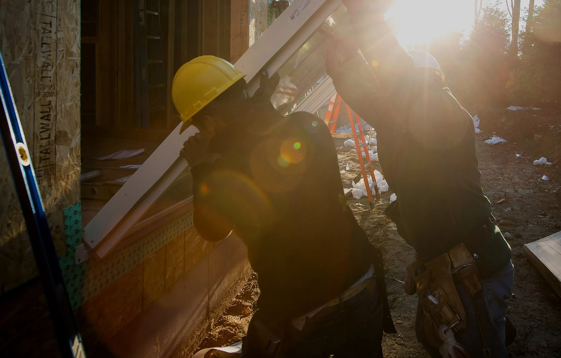 Workers install a sliding door on a home under construction in Rye Brook, N.Y.
