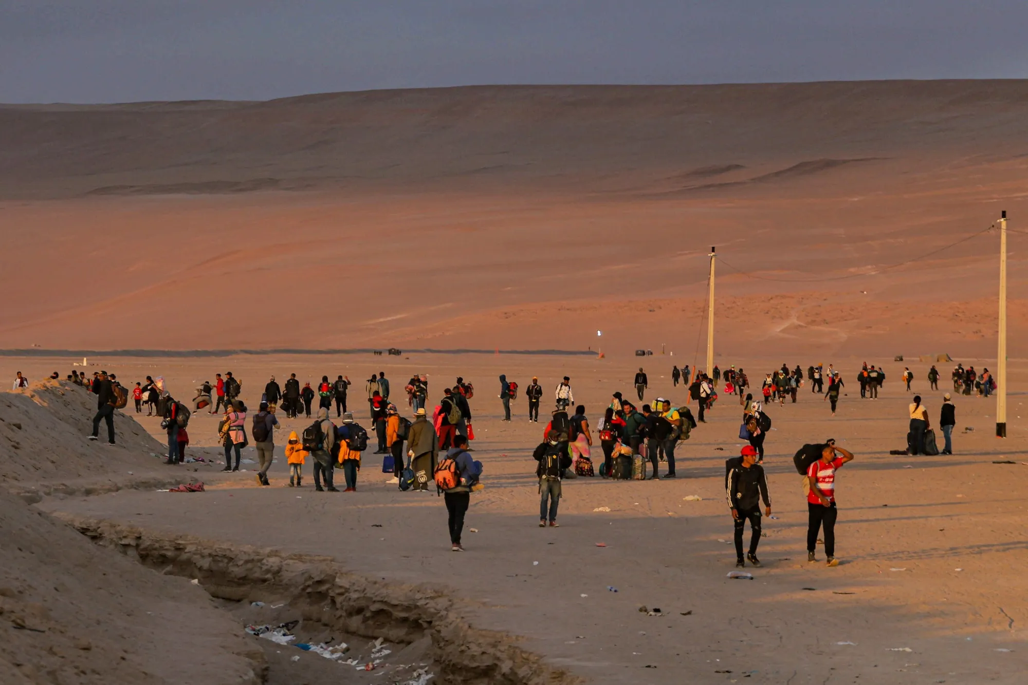 Migrants walk through the desert in the direction of Peru after clashes with the Chilean and Peruvian police, near Arica, Chile, in 2023.