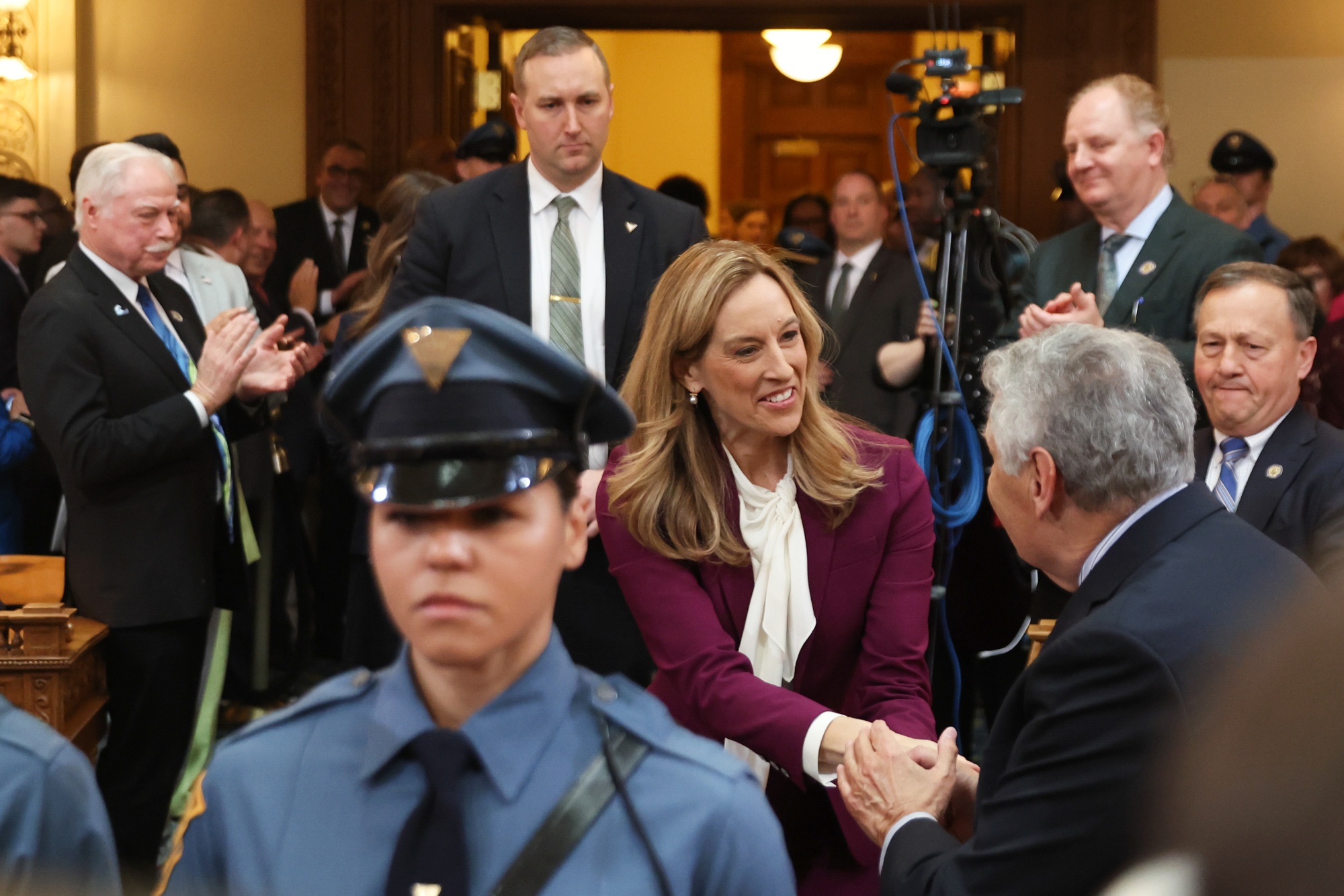 Mikie Sherrill, governor of New Jersey, greets lawmakers while arriving to speak in the Assembly Chamber of the New Jersey State House in Trenton, New Jersey, US, on Tuesday, March 10, 2026. Sherrill said Tuesday she wants to scale back the state's new property tax relief program for senior citizens to help close a $3 billion structural deficit, laying out a conservative spending plan in her first budget address since entering office in January. Photographer: Heather Khalifa/Bloomberg