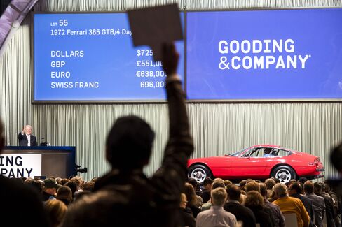 A bidder holds up a paddle as he bids for a 1972 Ferrari 365 GTB/4 Daytona during the Gooding & Company auction on Saturday, Aug. 20, 2016.