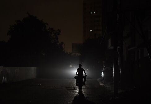 A motorist drives on an unlit street during a power cut in Karachi in July 2015.