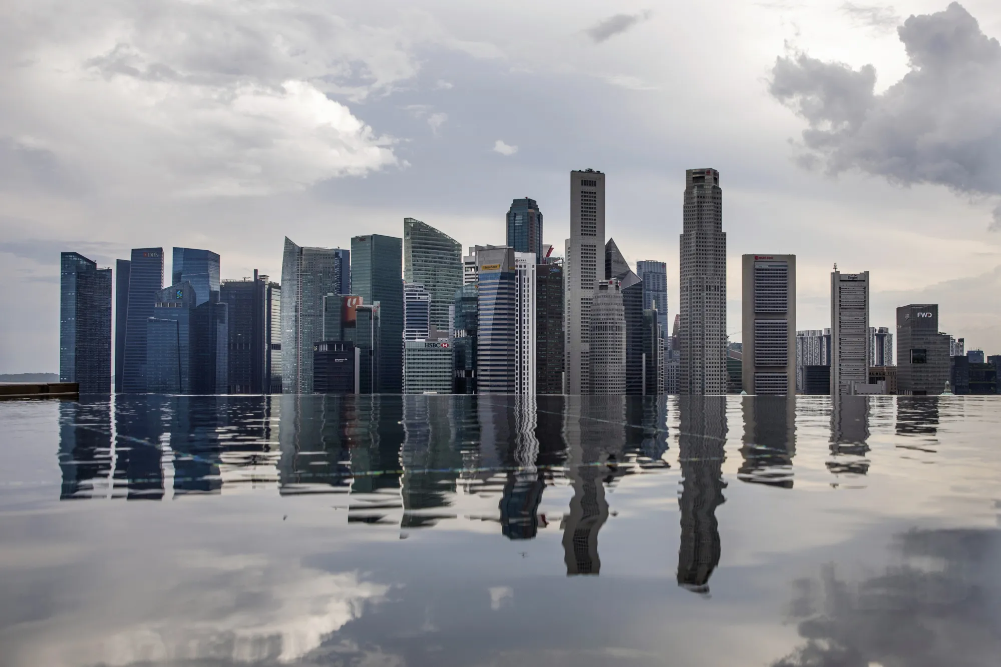 Commercial buildings standing in the central business district are reflected in a rooftop pool in Singapore.