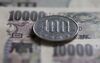 A Japanese 100 yen coin and 10,000 yen banknotes