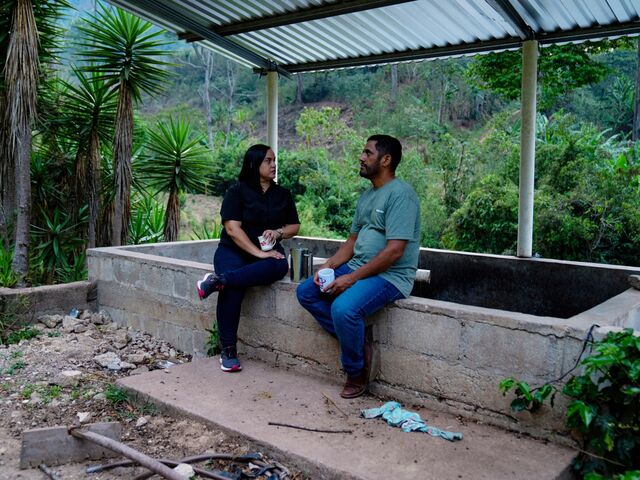 Raquel Giron and her brother Octavio Giron drink coffee made from their own crops at their farm at sunset.