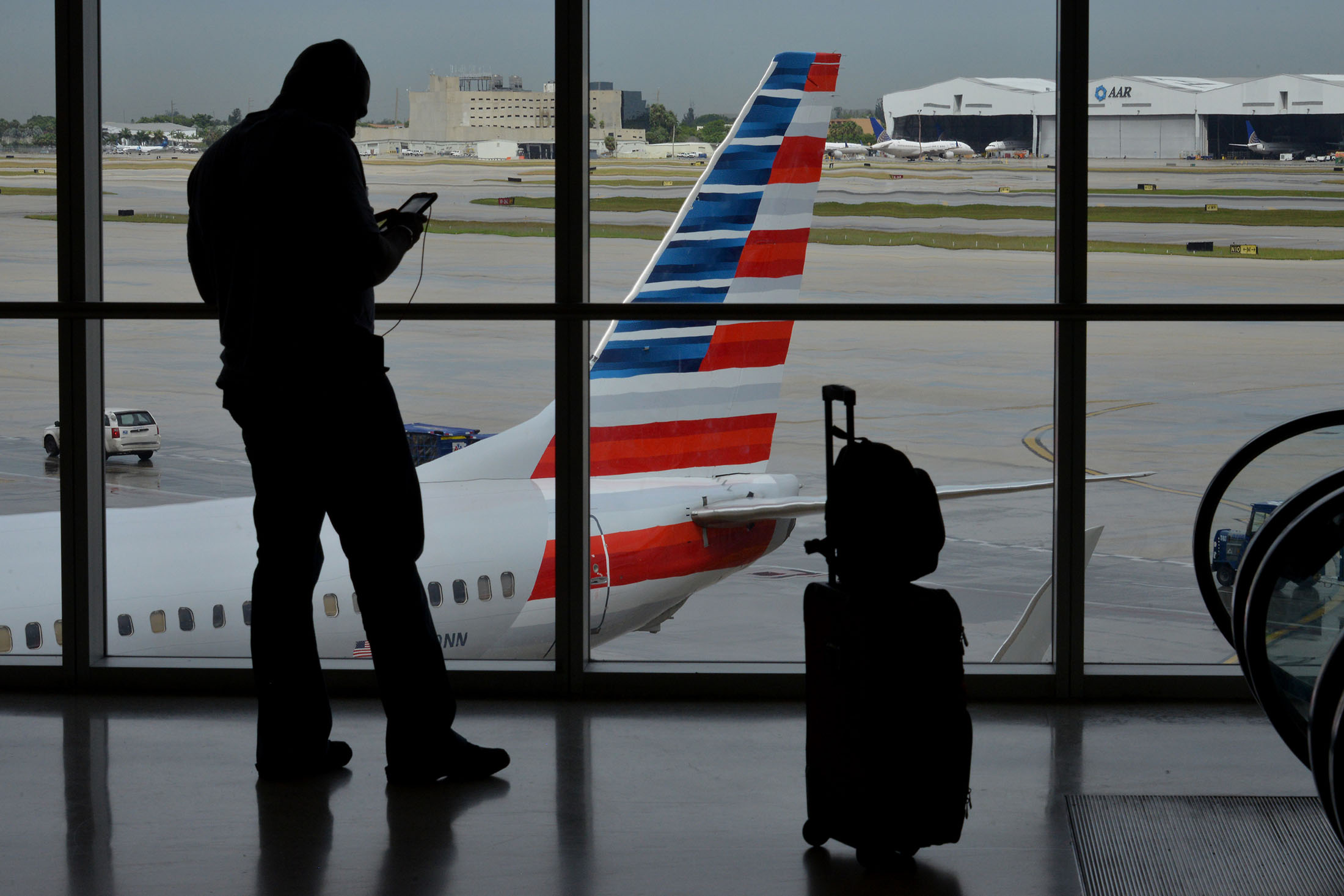 The silhouette of a traveler is seen at the American Airlines Group Inc. terminal of Miami International Airport (MIA) in Miami, Florida, U.S., on Tuesday, Sept. 23, 2014. American Airlines Group Inc. is scheduled to release earnings figures on Oct. 17.

