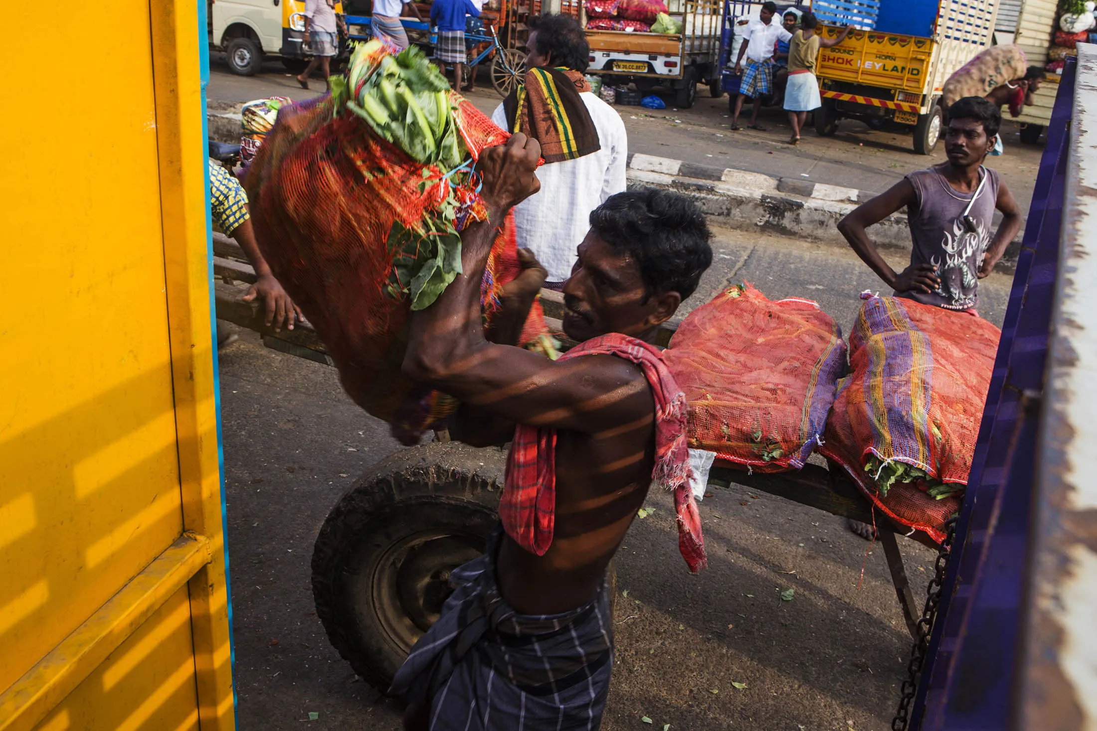 A worker unloads vegetables from a truck at a market in Chennai.
