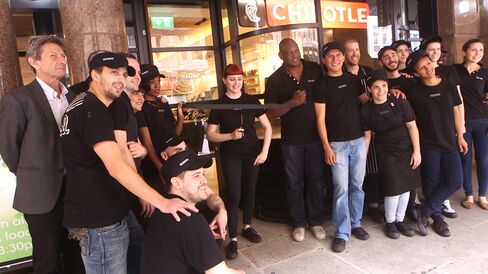 Staffers gather outside Chipotle's new London restaurant for a ribbon-cutting ceremony.
