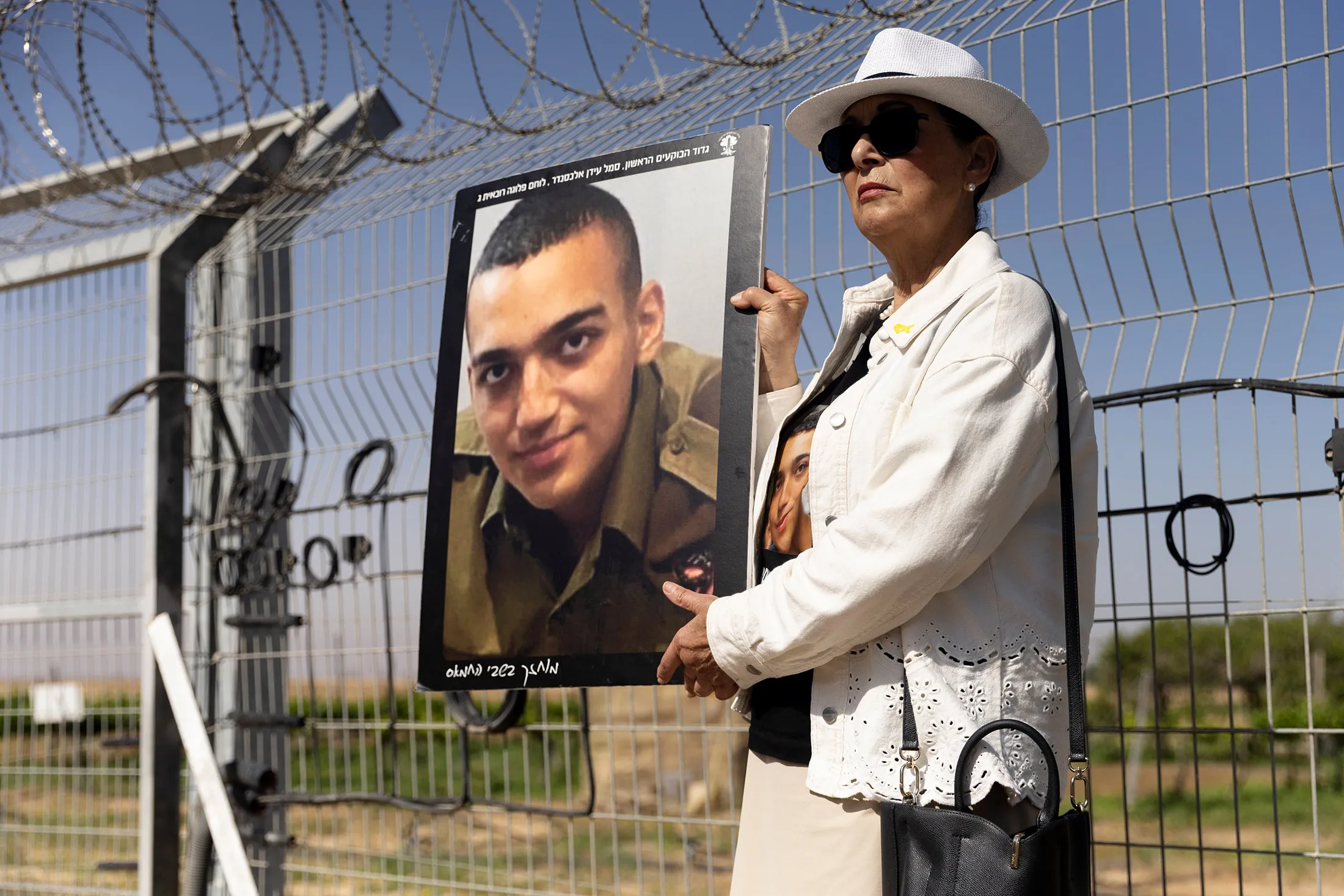 Varda Ben Baruch holds a photo of her grandson, Edan Alexander, during a rally in Nir Oz, Israel, on April 20.