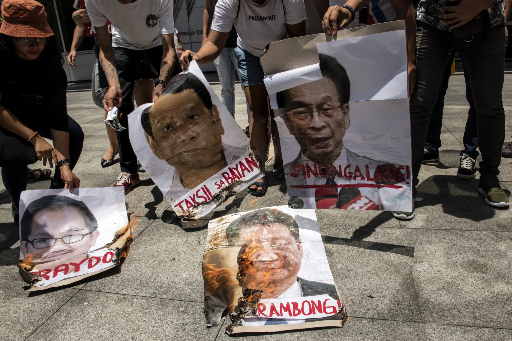 Protesters burn images of Xi, Duterte, and local officials during a protest outside the Chinese Embassy on June 25.