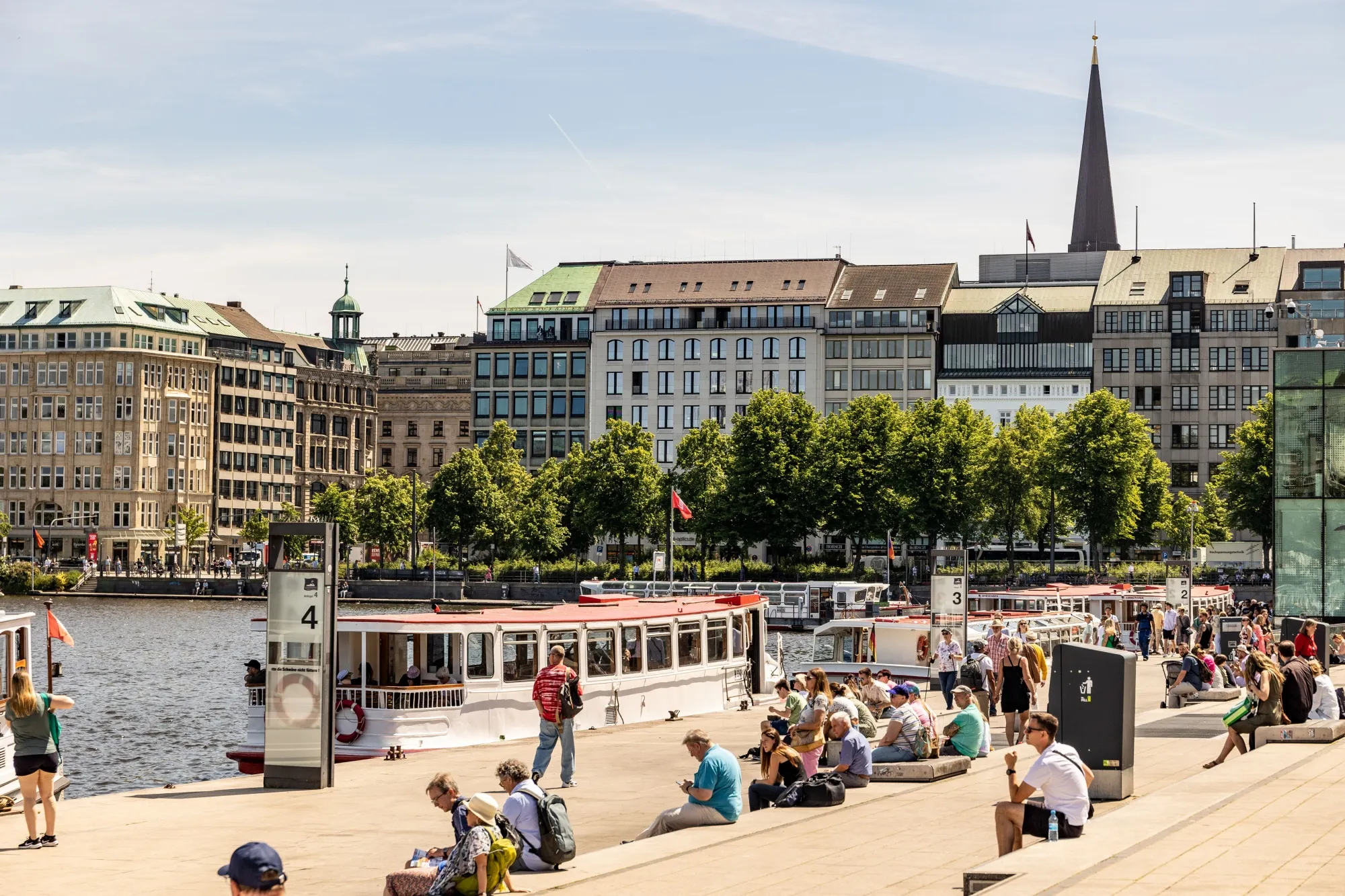 Pedestrians relax on the bank of Alster lake in Hamburg, Germany.