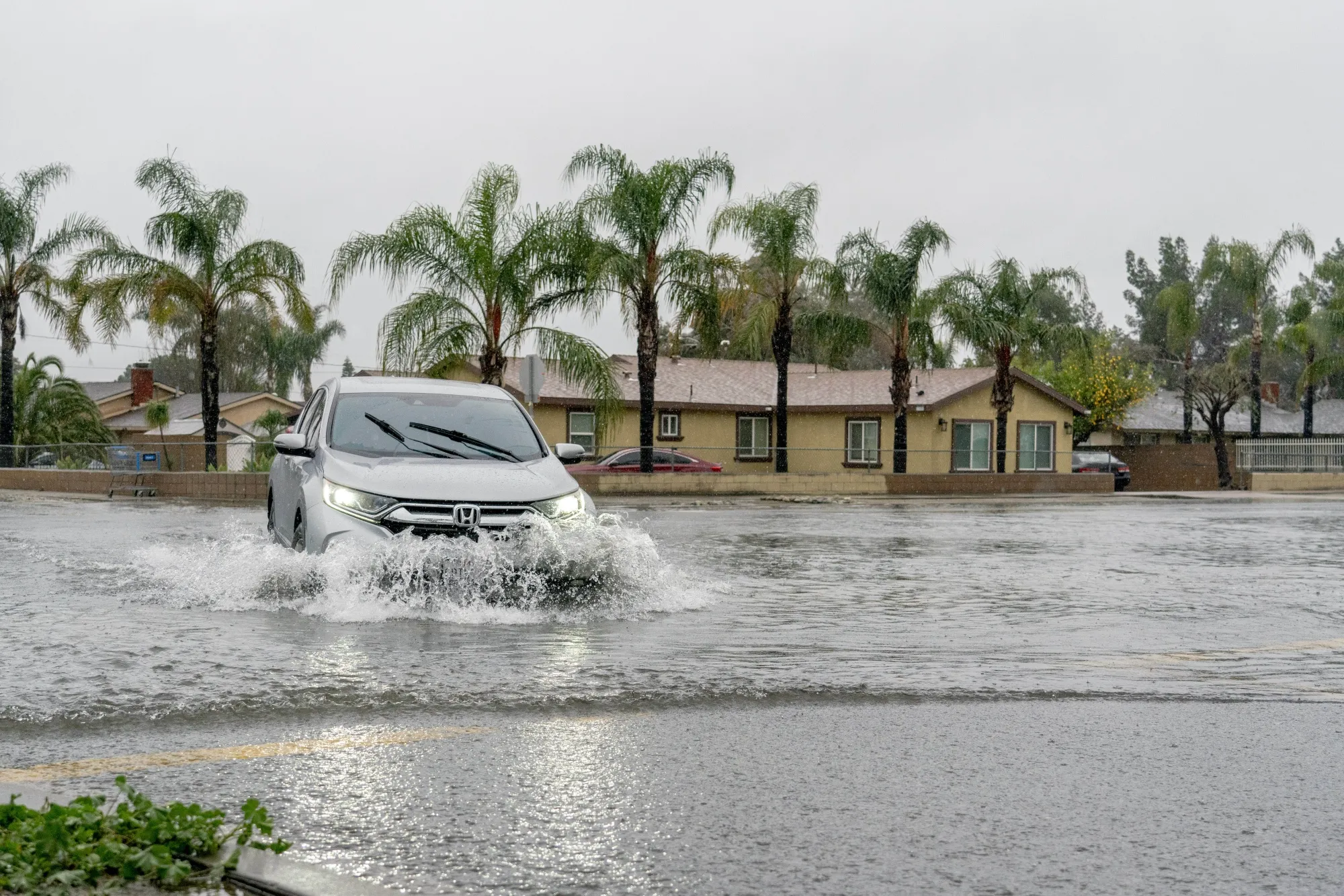 A driver plows&nbsp;through floodwaters during a storm in Fontana, California, in February.&nbsp;
