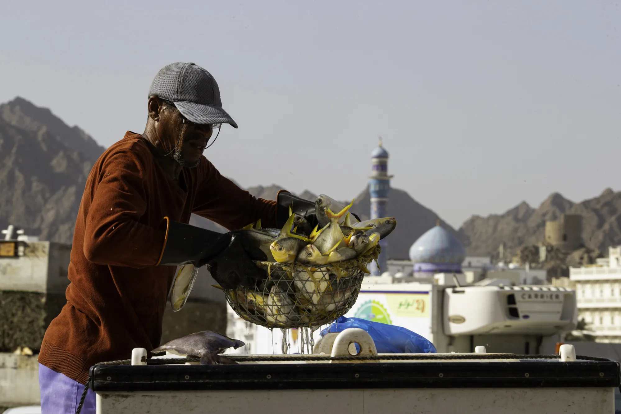 A fish trader moves a basket of fresh fish at the Mutrah fish market in Muscat, Oman.
