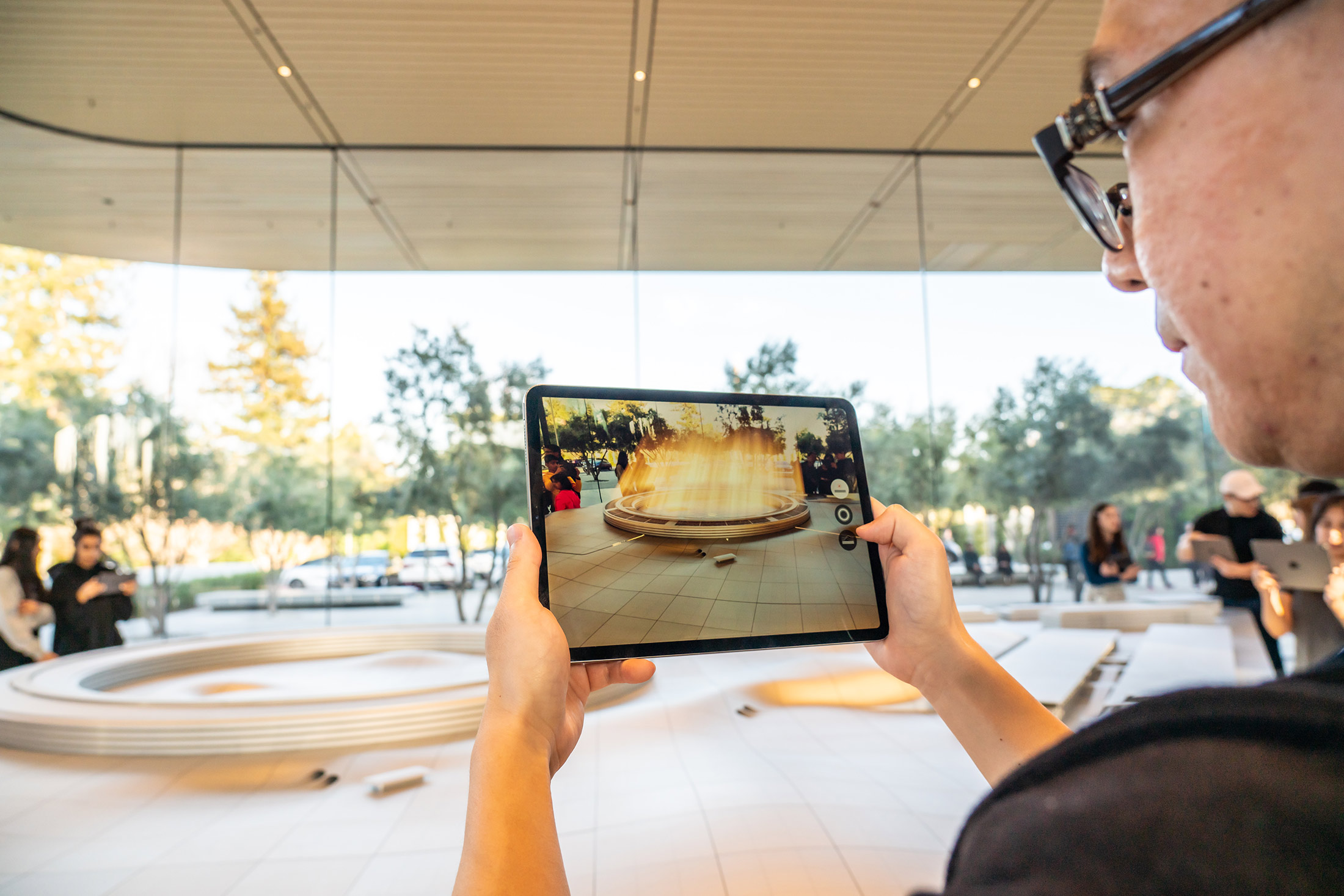 A customer uses an iPad for an augmented reality tour to see a virtual version of the Apple Park campus in Cupertino, California.