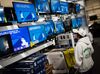 A shopper looks at televisions displayed for sale.