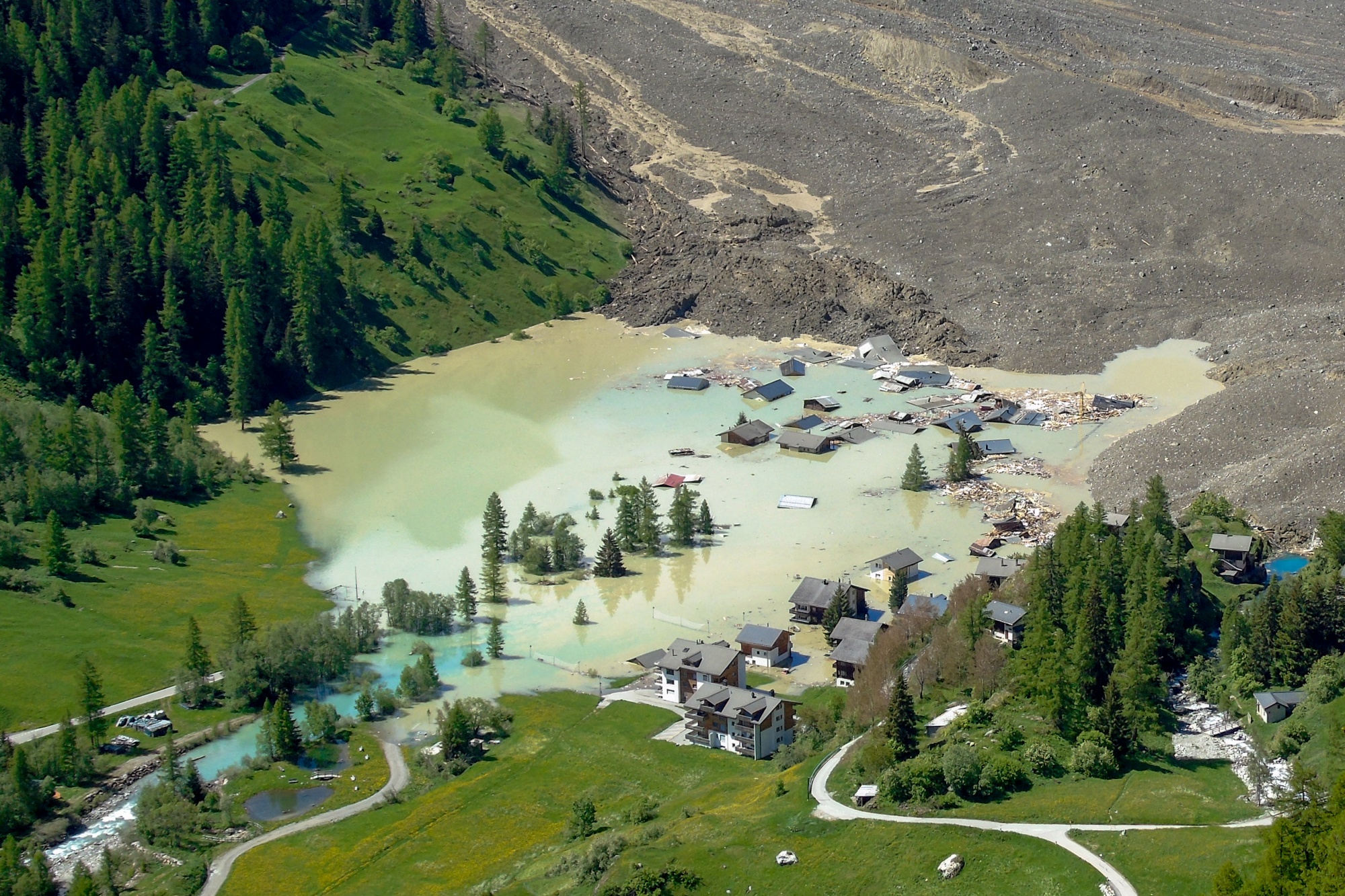 This photograph shows the small village of Blatten, in the Bietschhorn mountain of the Swiss Alps, destroyed by a landslide after part of the huge Birch Glacier collapsed and swallowed up by the river Lonza the day before, in Blatten on May 29, 2025. Swiss authorities were on May 29, 2025 monitoring for possible flood risk in a southern valley, following a massive glacier collapse that created a huge pile of debris after destroying a small village. On May 28 the Birch glacier in Switzerland's southern Wallis region collapsed, sending tons of rock, ice and scree hurtling down the mountain slope and into the valley below. The barrage largely destroyed the hamlet of Blatten, which had been home to 300 people and was evacuated last week due to the impending danger. (Photo by ALEXANDRE AGRUSTI / AFP) (Photo by ALEXANDRE AGRUSTI/AFP via Getty Images) Photographer: ALEXANDRE AGRUSTI/AFP