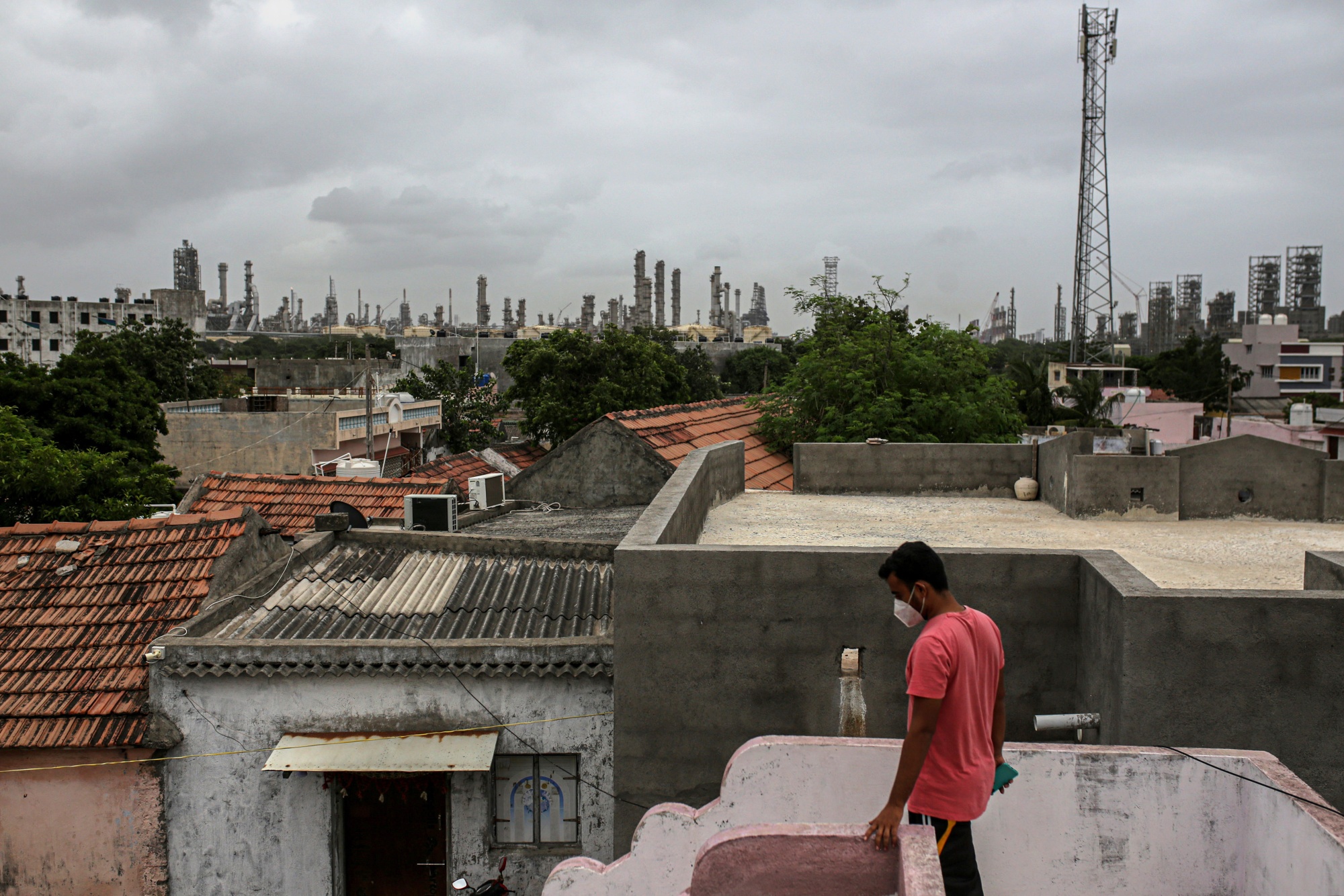 The refinery towers over the rooftops of nearby villages. 