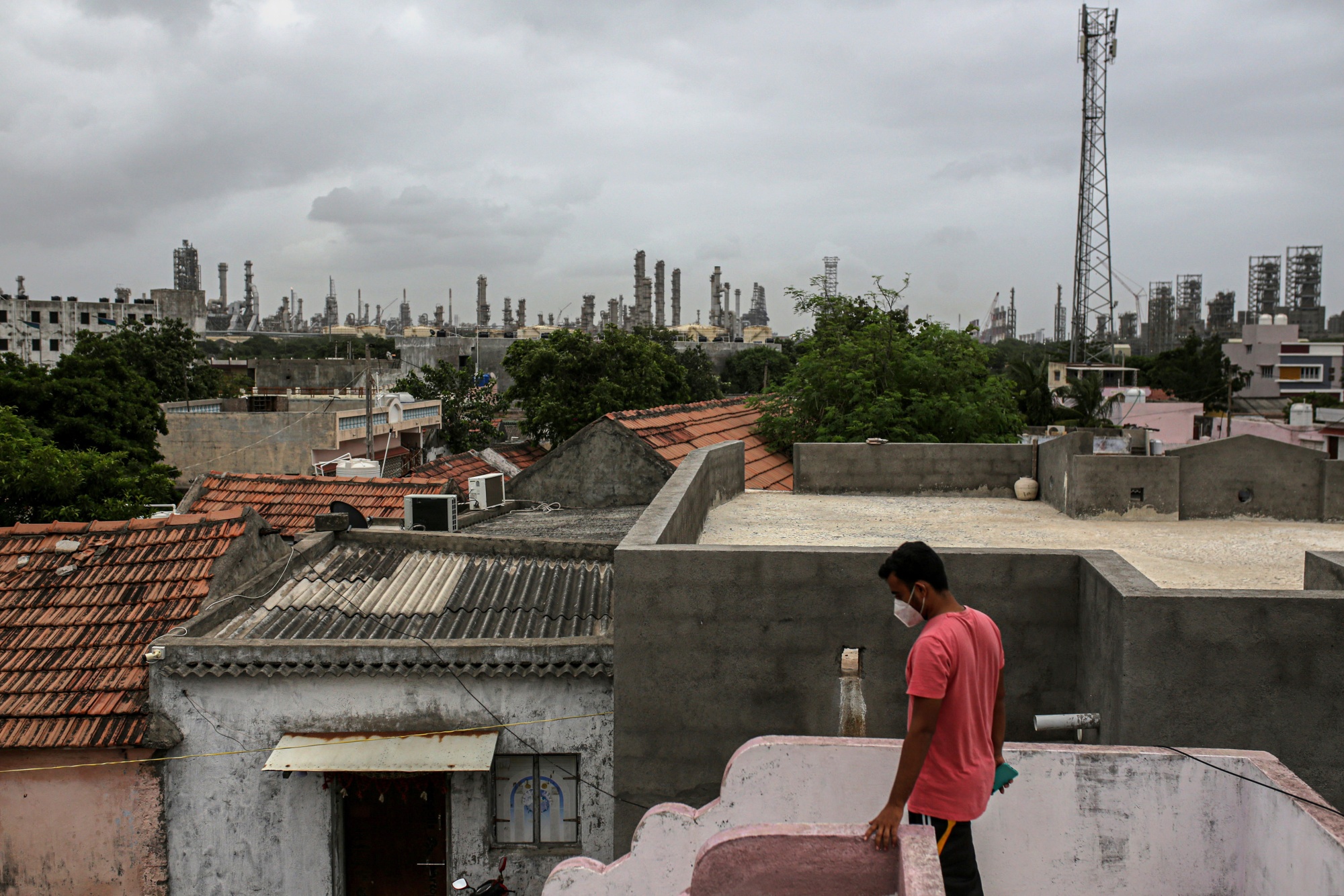 The refinery towers over the rooftops of nearby villages.