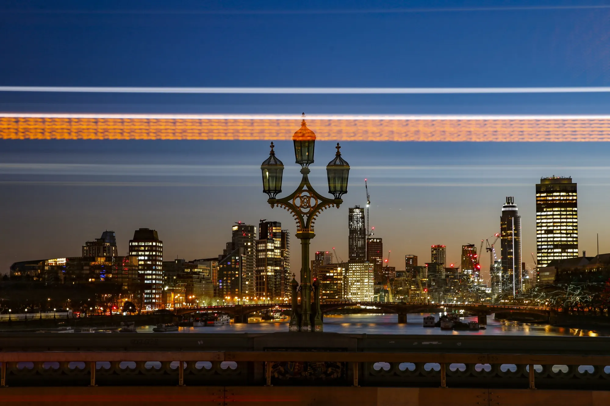 Automobiles cast light trails as they travel across Westminster Bridge in London.