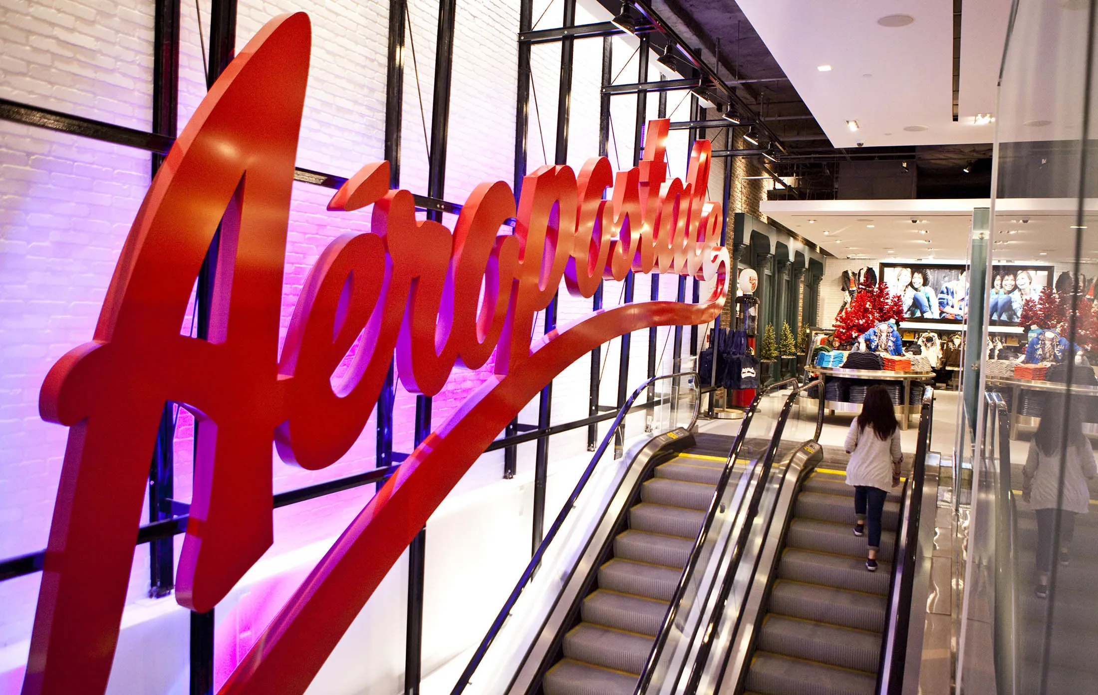 A girl rides up an escalator at Aeropostale's newest flagship store in Times Square in New York.
