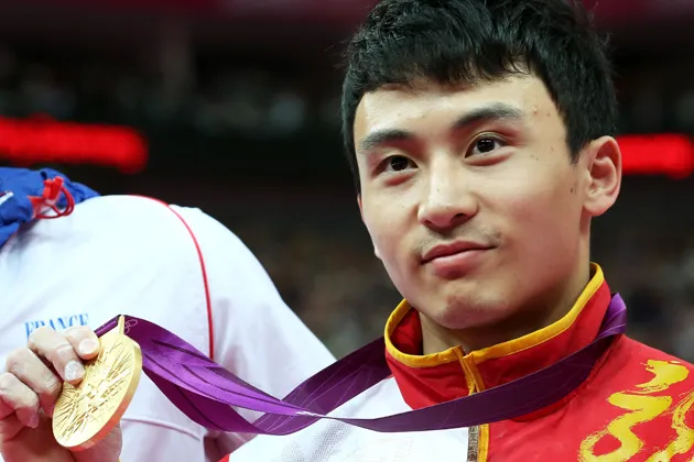 Gold medalist Zhe Feng of China poses on the podium during the medal ceremony for the Artistic Gymnastics Men's Parallel Bars