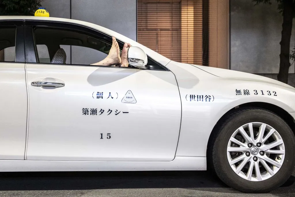 A cabdriver&nbsp;takes a nap at night in Tokyo's Ginza area (2022).&nbsp;