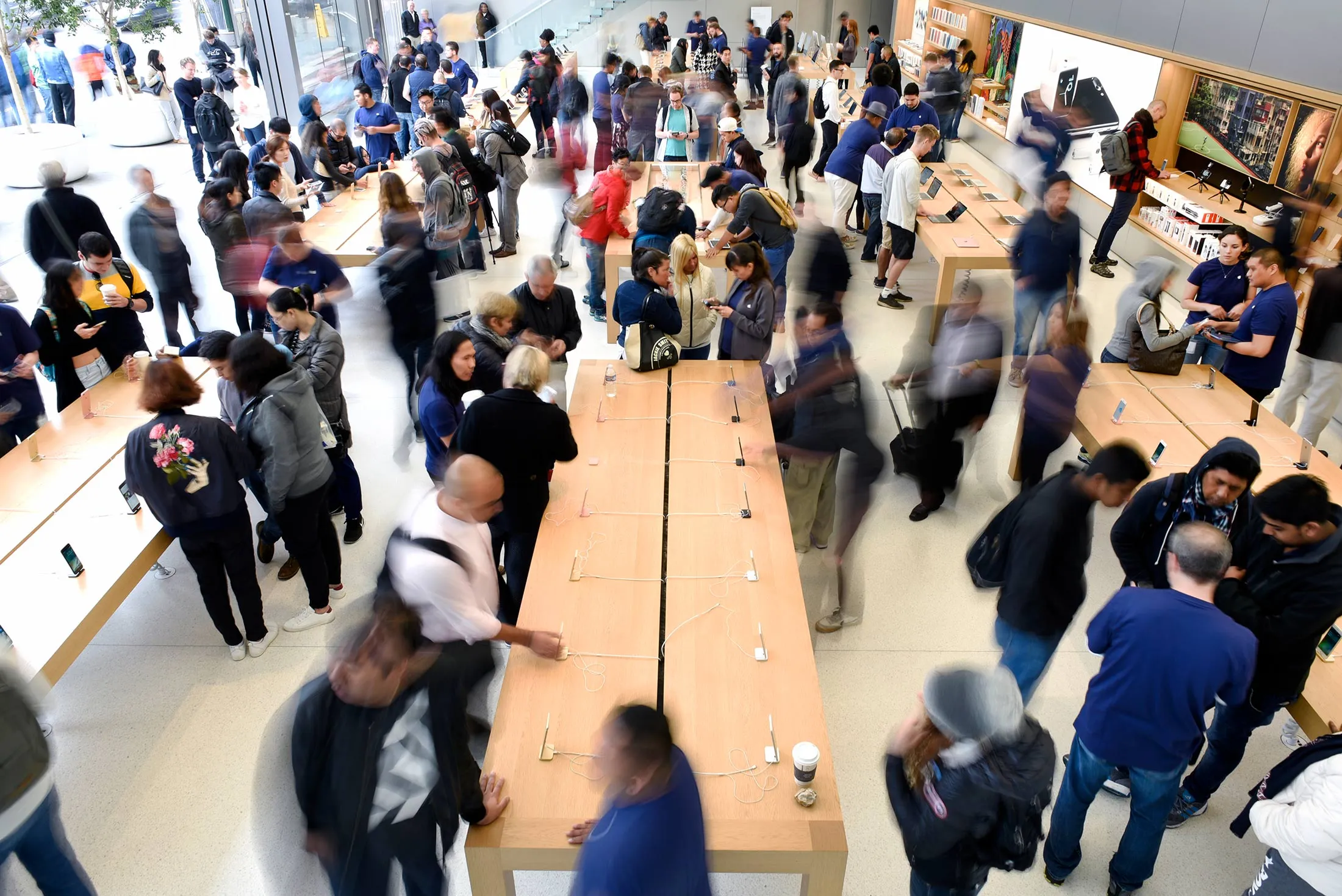 Customers browse products during the release of the Apple Inc. iPhone 7 and 7 Plus smartphones at an Apple Inc. in San Francisco, California, U.S., on Friday, Sept. 16, 2016. Shoppers looking to buy Apple Inc.'s new iPhone 7 smartphones on Friday better have ordered ahead. Brisk demand left some stores sold out, leaving those who purchased online with the best chance to get their hands on the latest models -- and some resorting to extreme measures.

