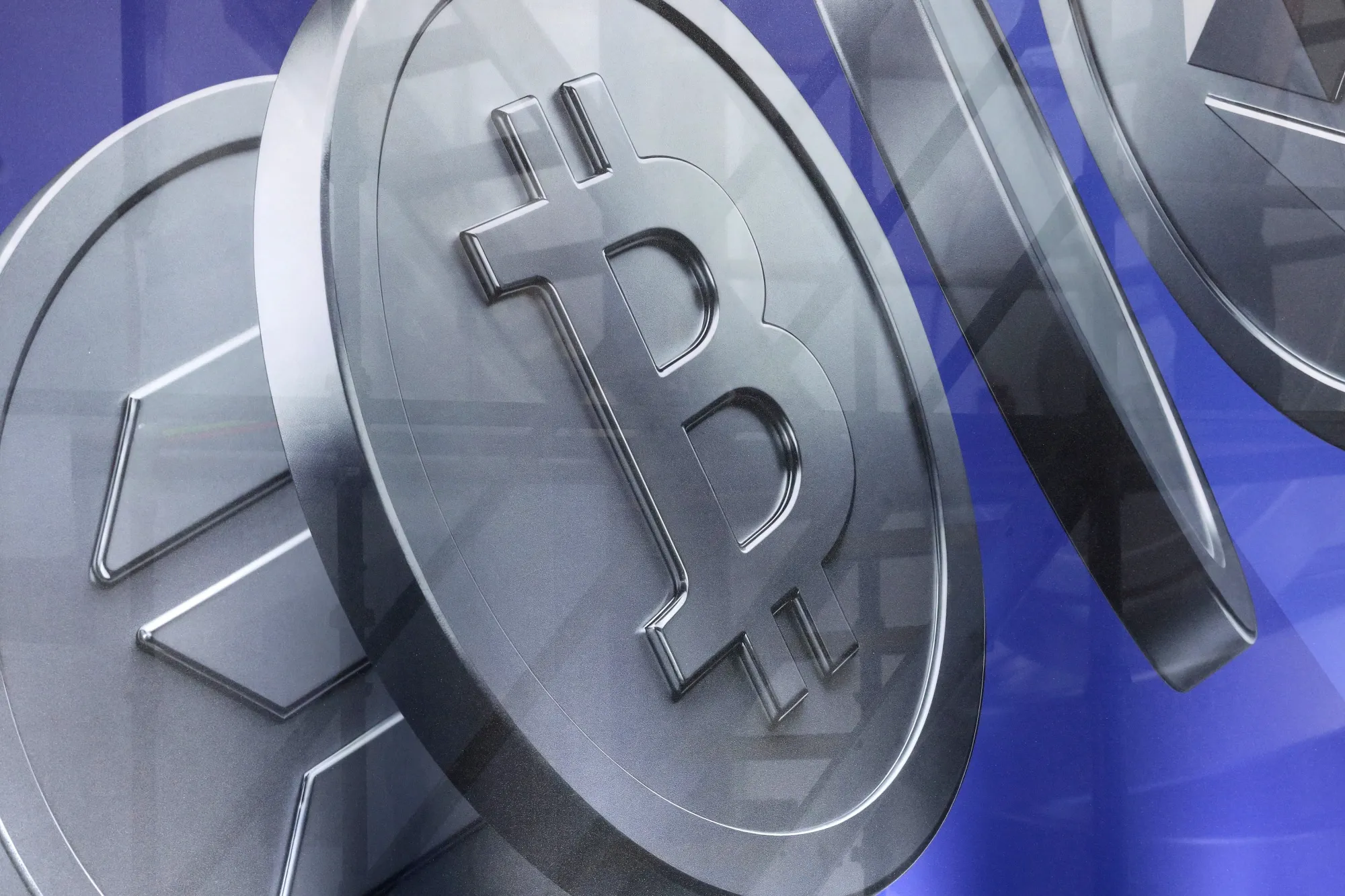 An image of Bitcoin and other cryptocurrency tokens displayed at a conference.