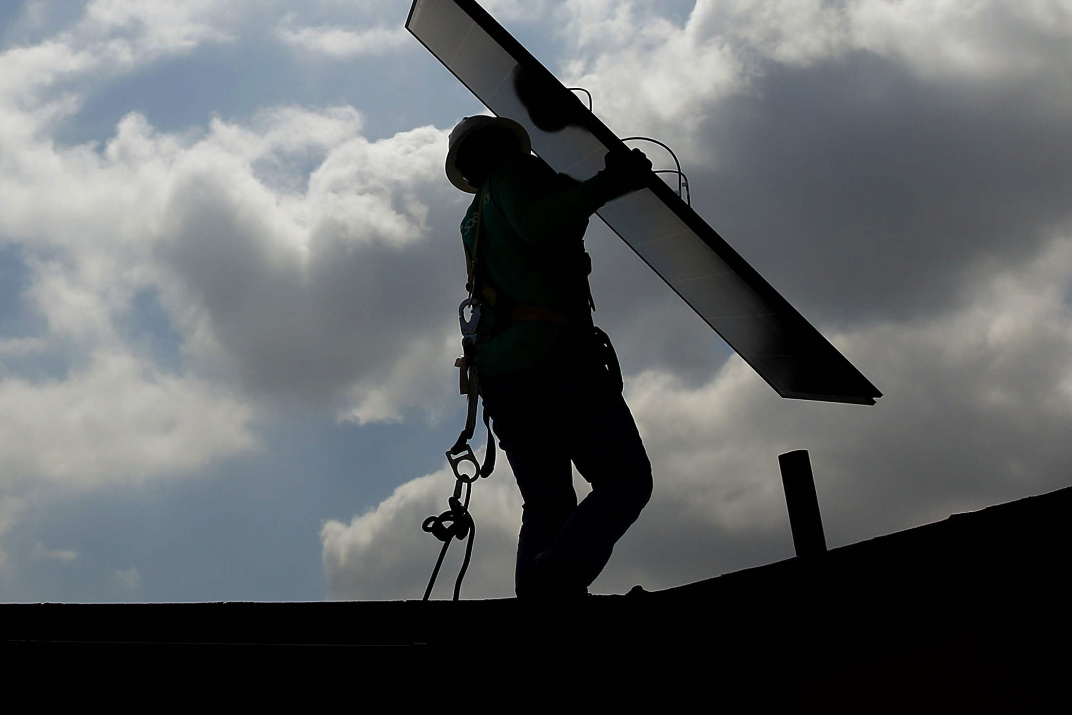 A worker carries a solar panel during an installation in Los Angeles, California.