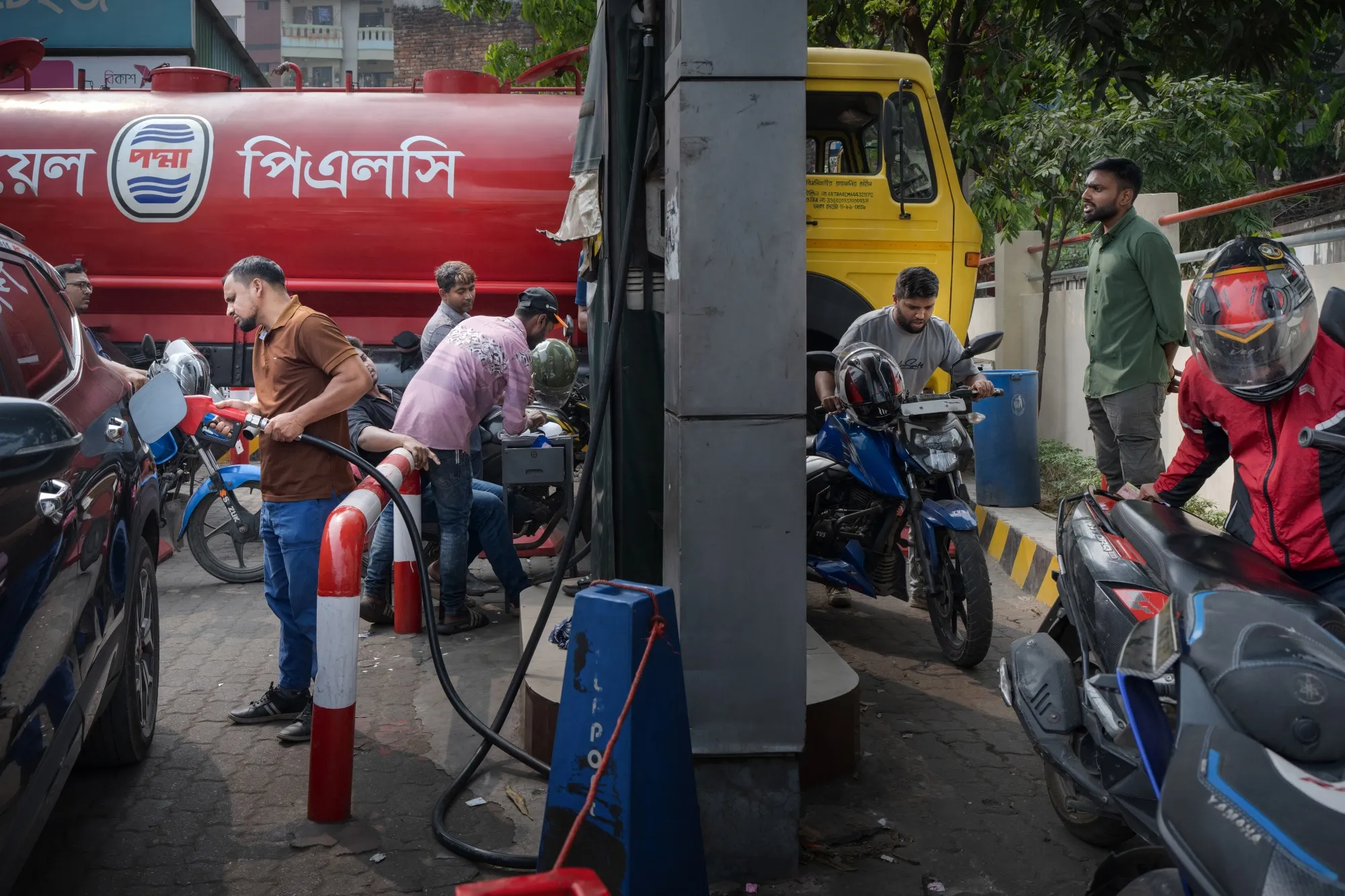 People refuel at a petrol station in Dhaka, Bangladesh.