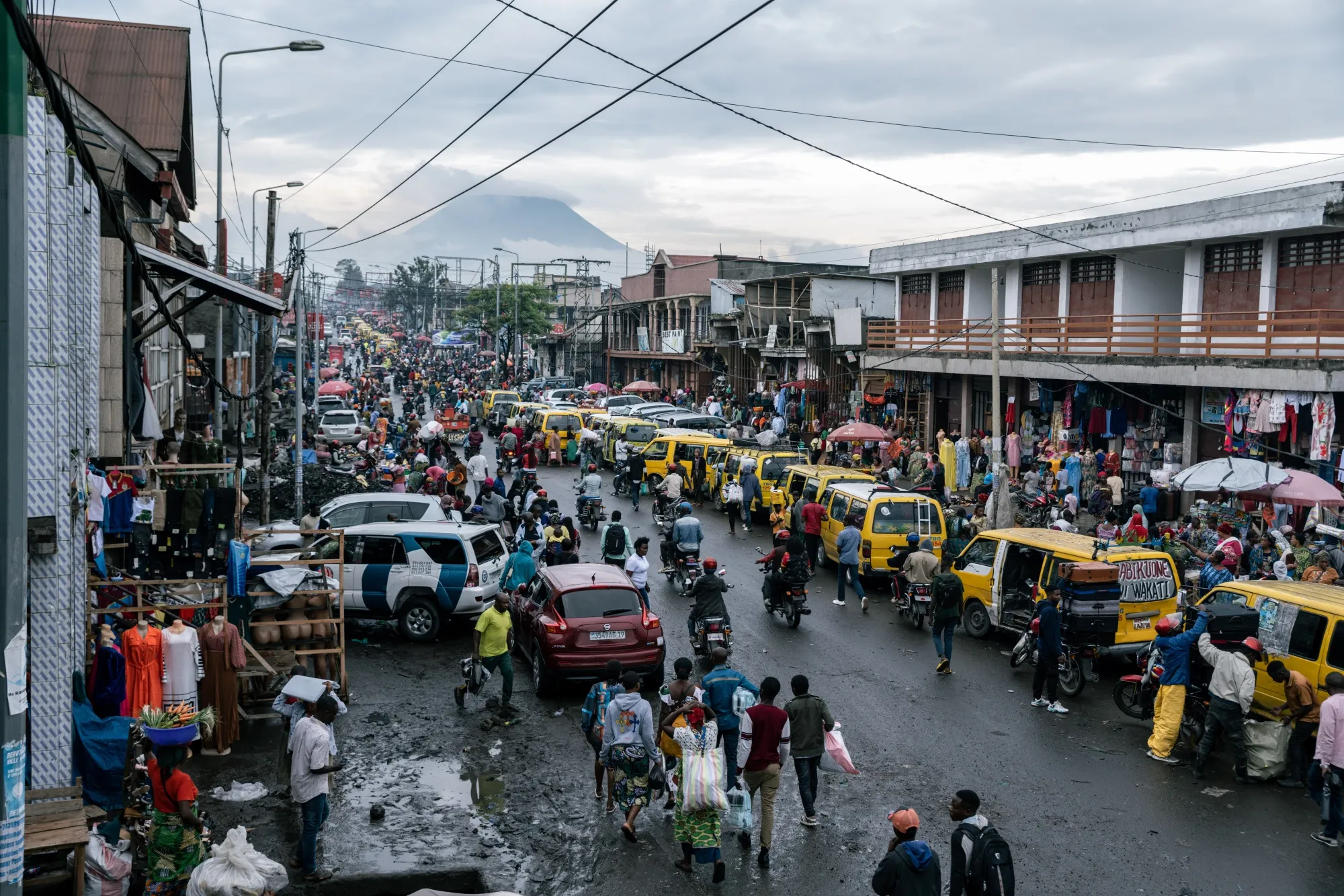 Shoppers and pedestrians pass lines of taxis and stores at Birere market in Goma, Democratic Republic of Congo.