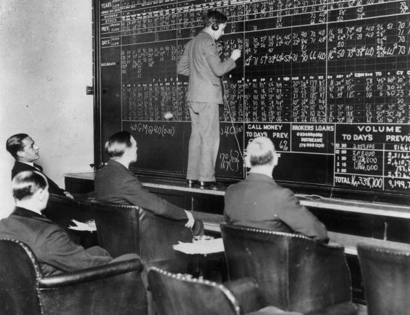 31st October 1929: In a London club run by St Phalle Ltd, members watch fluctuations in the New York stock market during the Wall Street crash as changes are chalked up by telephone operators in direct contact with New York. (Photo by London Express/Getty Images)