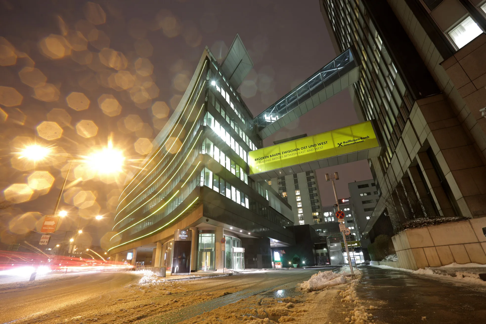 Lights illuminate office windows inside the headquarters of Raiffeisen Bank International AG as snow falls at night in Vienna, Austria, on Monday, Feb. 9, 2015. Raiffeissen Bank, eastern Europe's second-biggest lender, is curbing its Russian business and selling its Polish unit after turmoil in Ukraine caused its first-ever loss and marred prospects for the coming years.