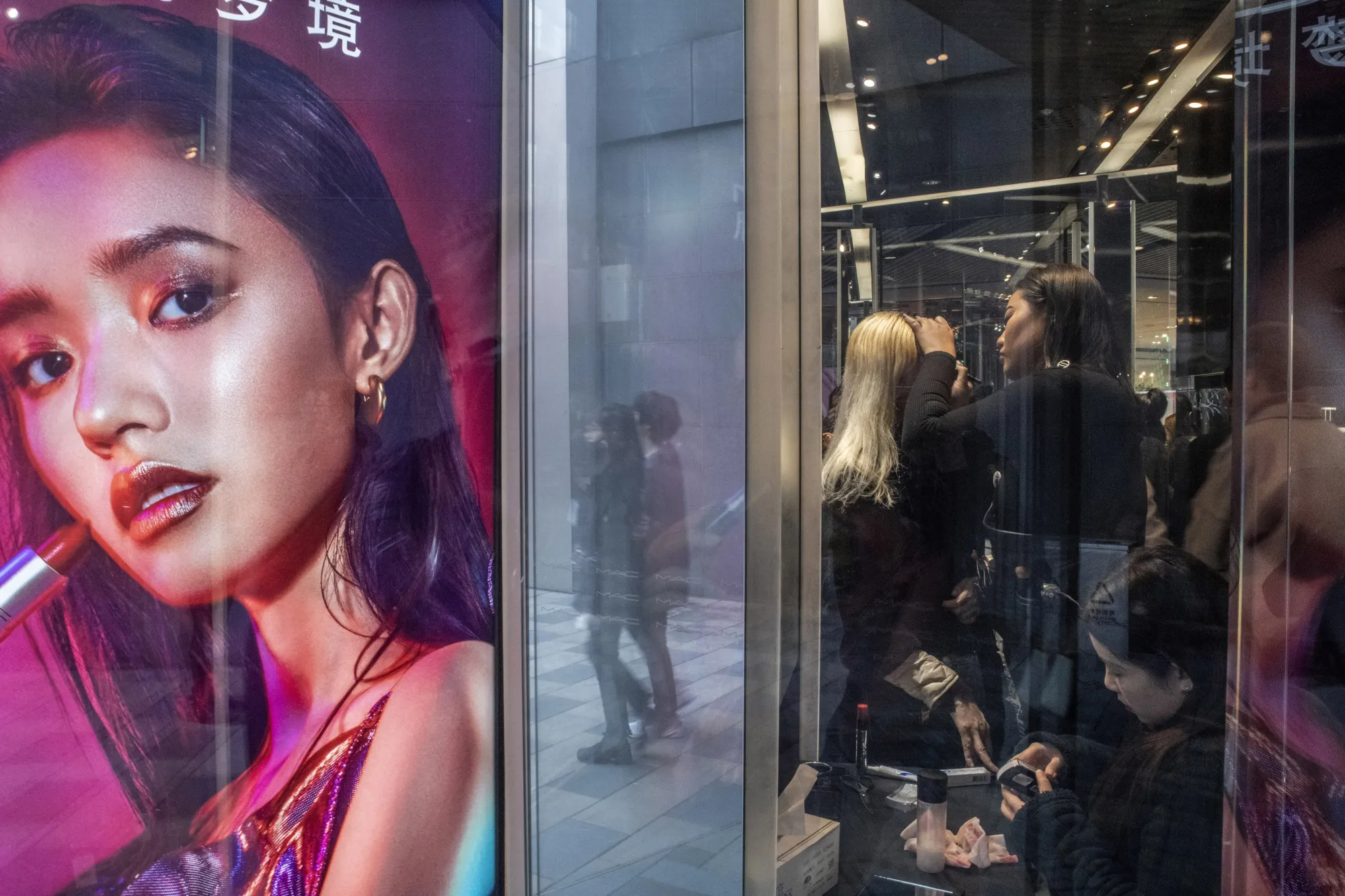 Customers try on make-up at a MAC Cosmetics store in Beijing, China.