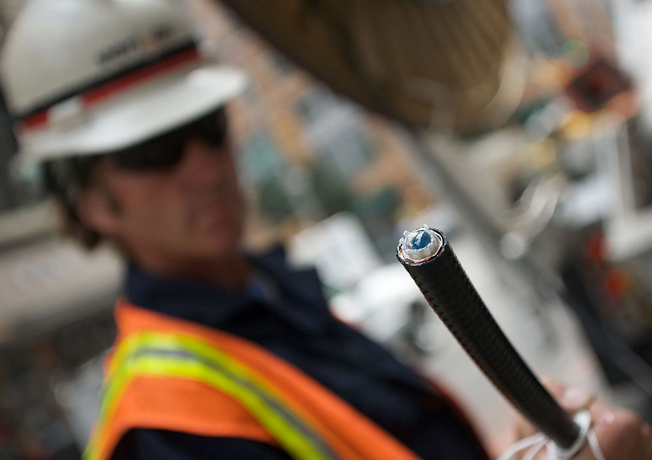 A Verizon technician prepares fiber-optic cables to install to a manhole in New York.
