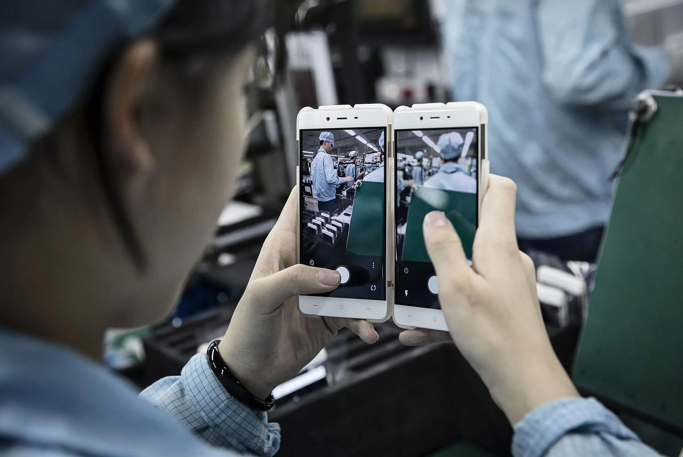 An employee tests the cameras of smartphones at a manufacturing facility in Dongguan, China.
