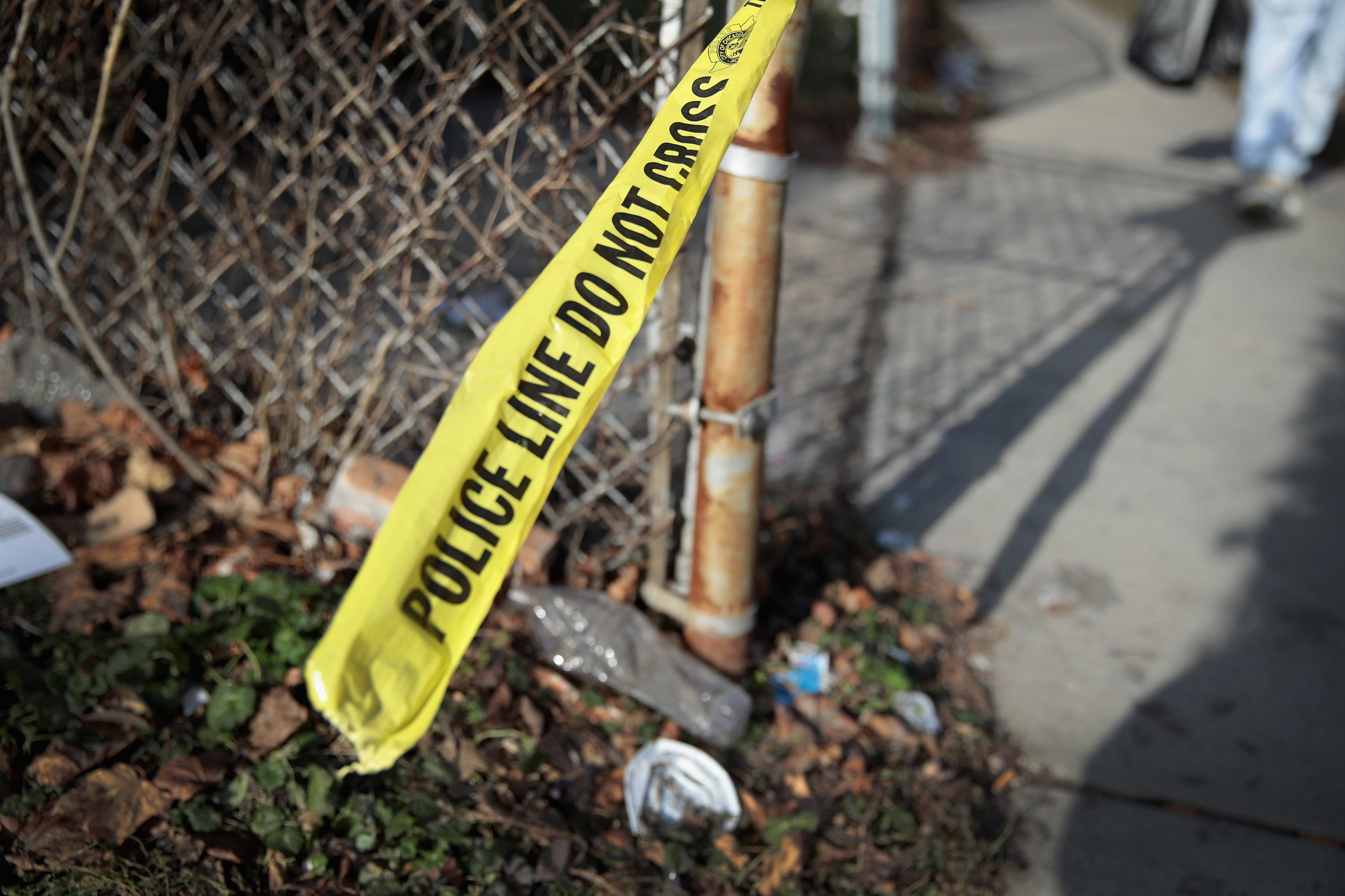Crime scene tape clings to a fence where in Chicago, where homicides are spiking this summer.&nbsp;
