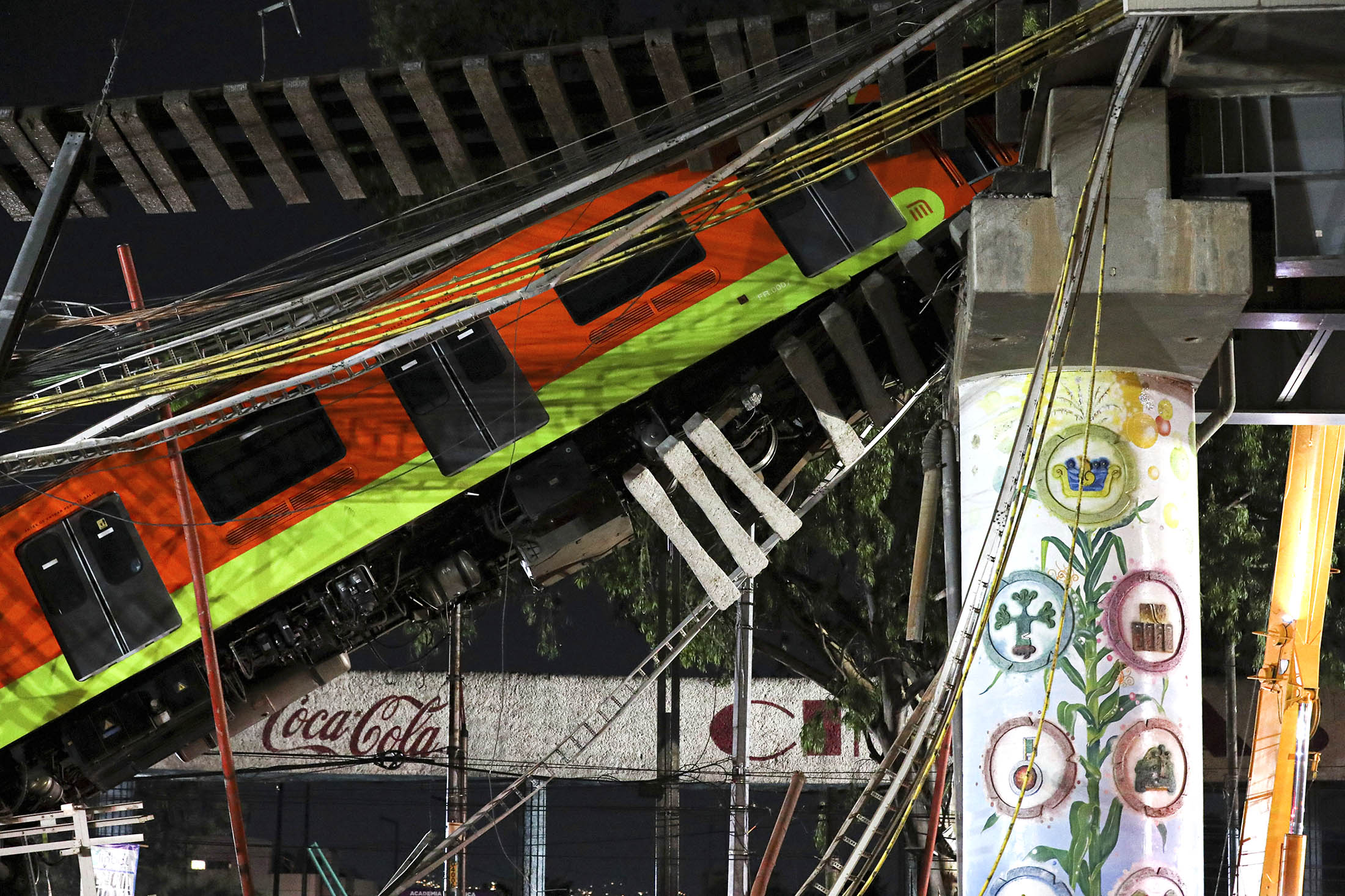 Train cars lay at an angle after a raised subway track collapsed in Mexico City.
