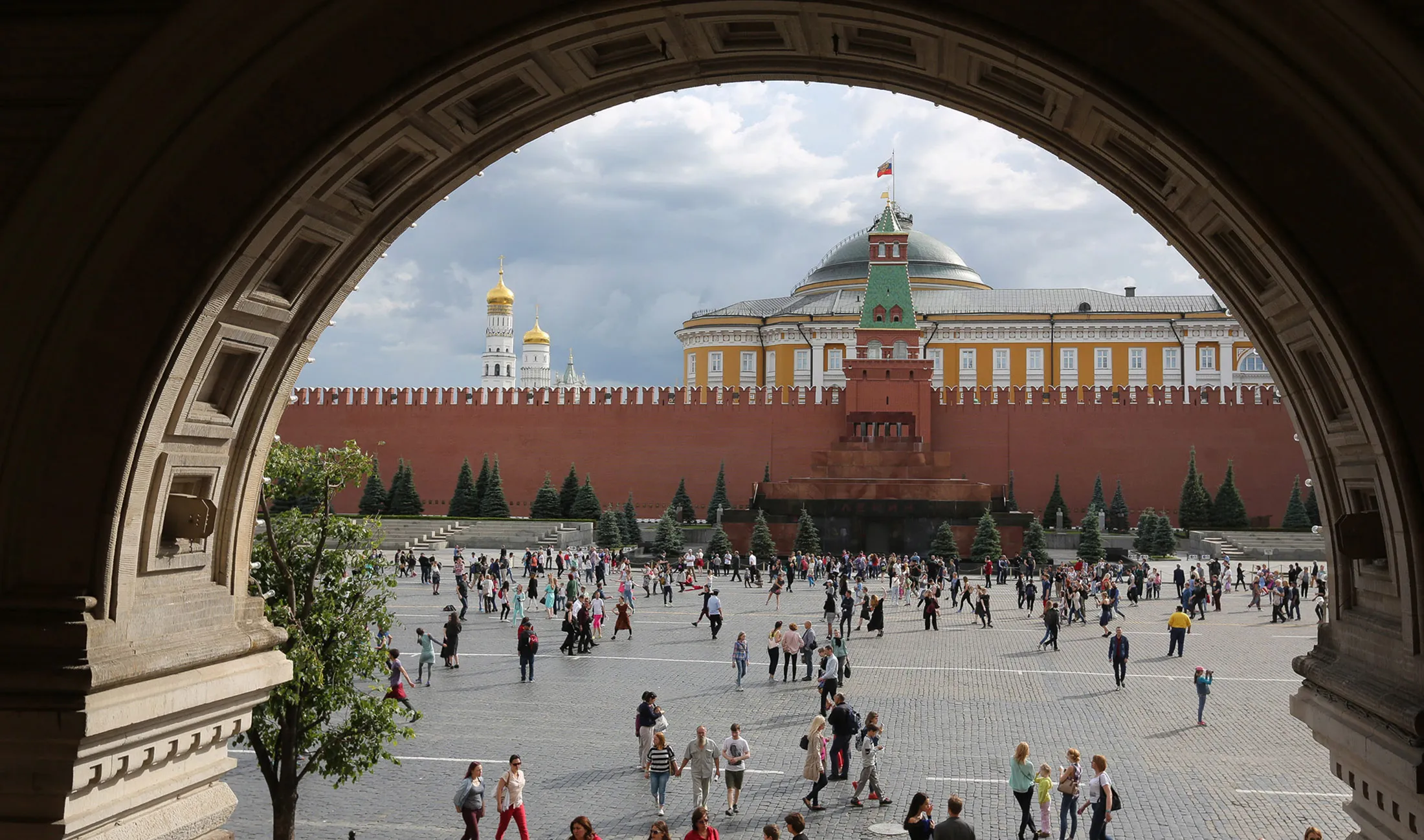 Tourists walk by The Kremlin in Moscow.