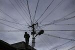 An electrician works&nbsp;on&nbsp;a utility pole in Coonoor, Tamil Nadu, India.