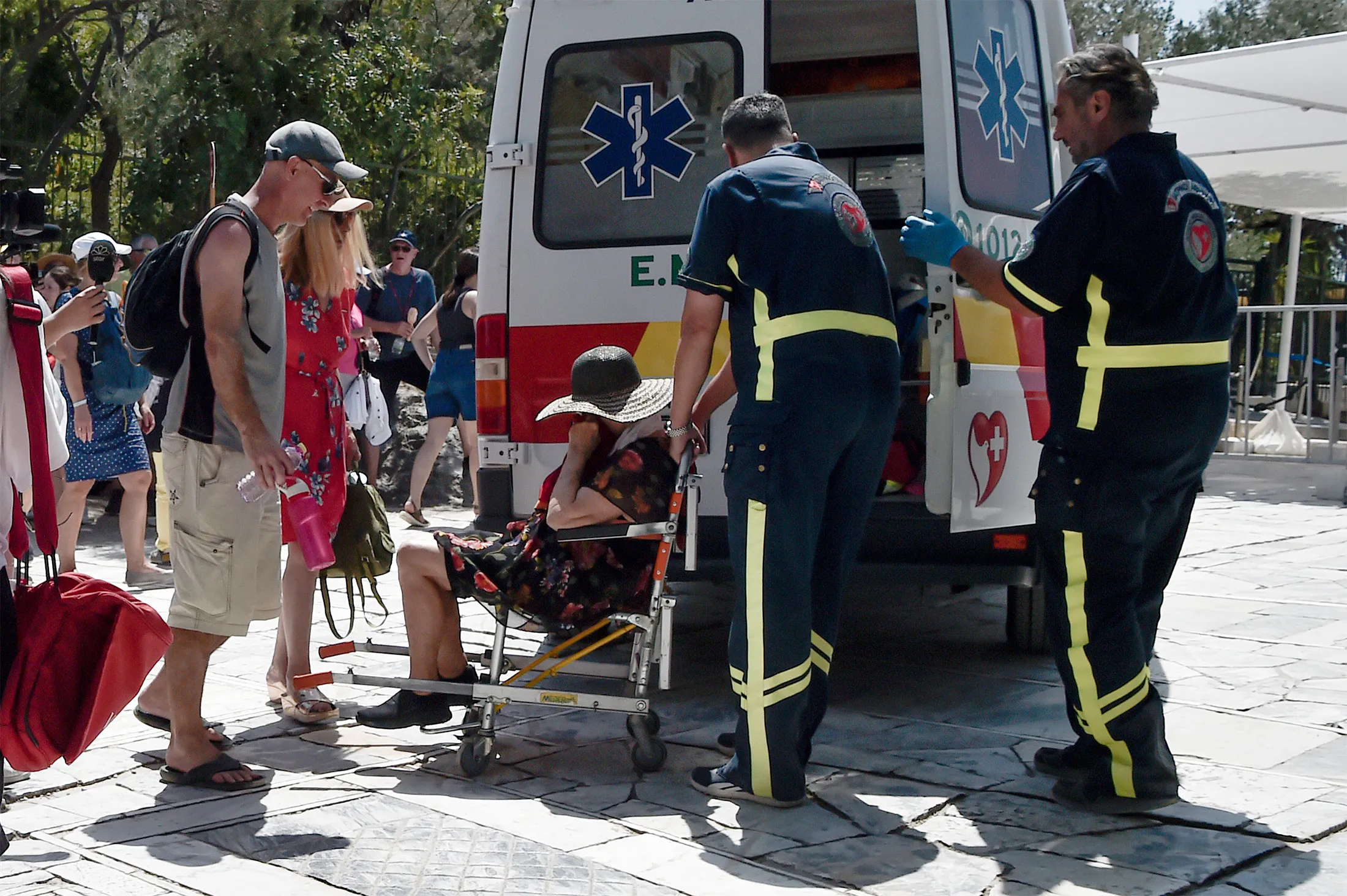 Medics help a woman who has passed out from the heat during a heat wave in Athens, Greece, on July 20.